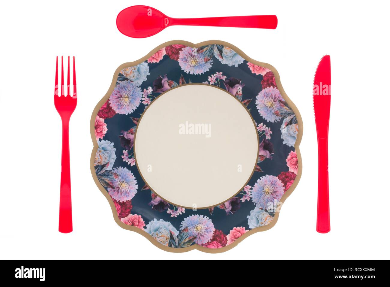 Piatto di carta blu floreale e posate di plastica rossa su sfondo bianco Foto Stock