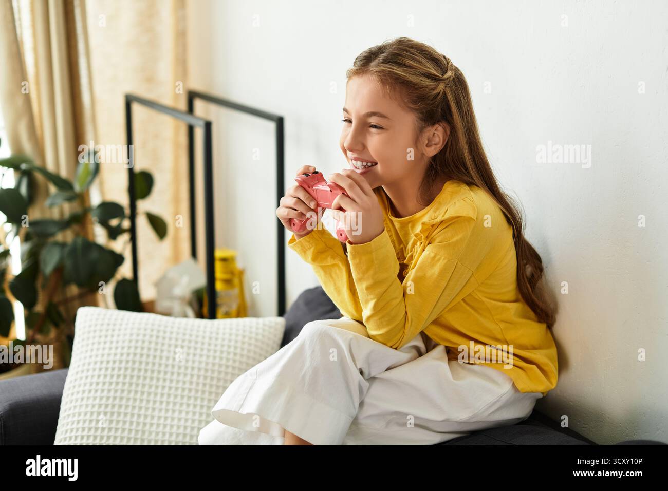 Una allegra ragazza alfa si rilassa a casa, giocando con il suo outfit casual Foto Stock