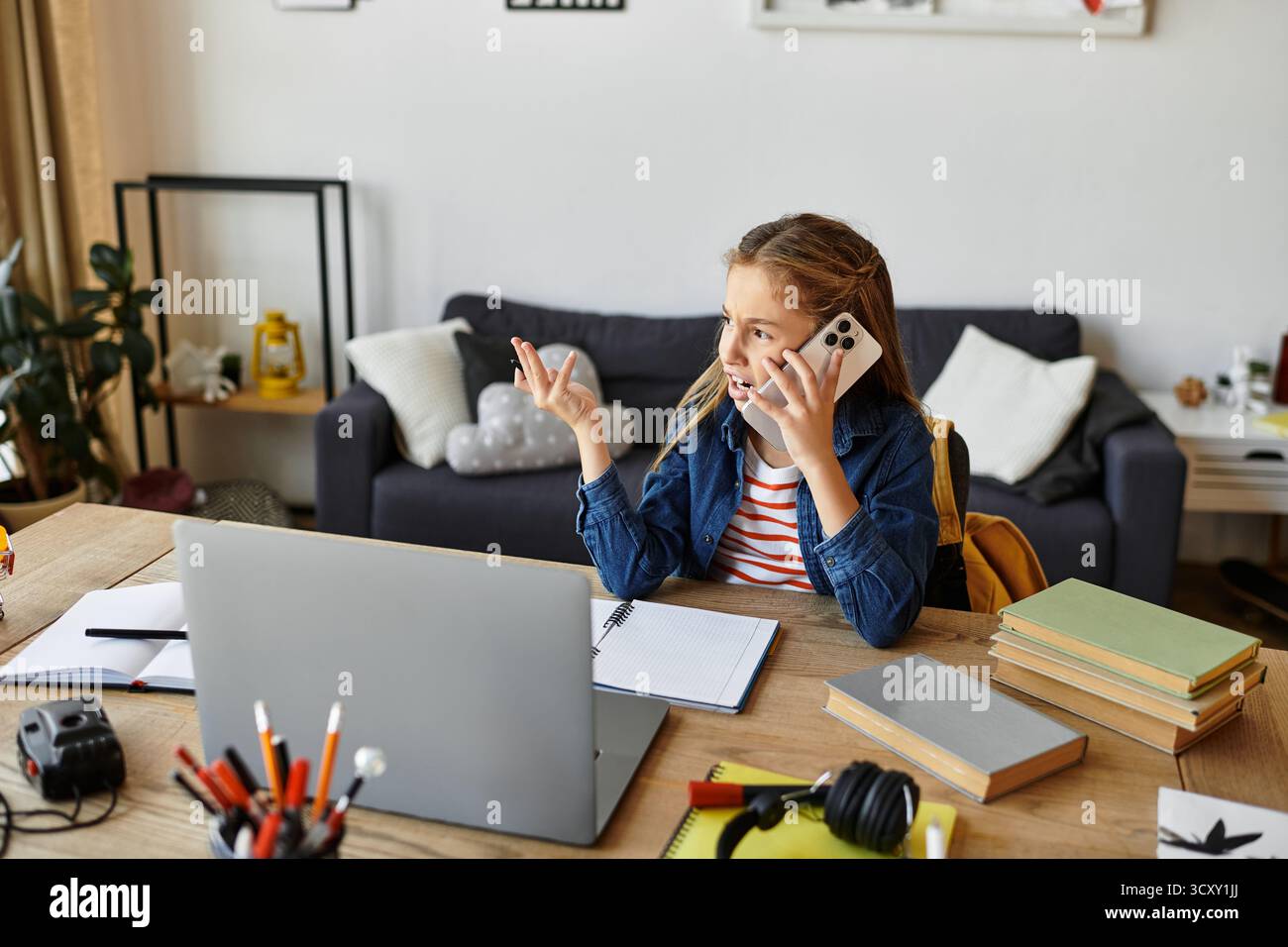 Ragazza occasionale a casa durante una telefonata mentre studiava, generazione alfa Foto Stock