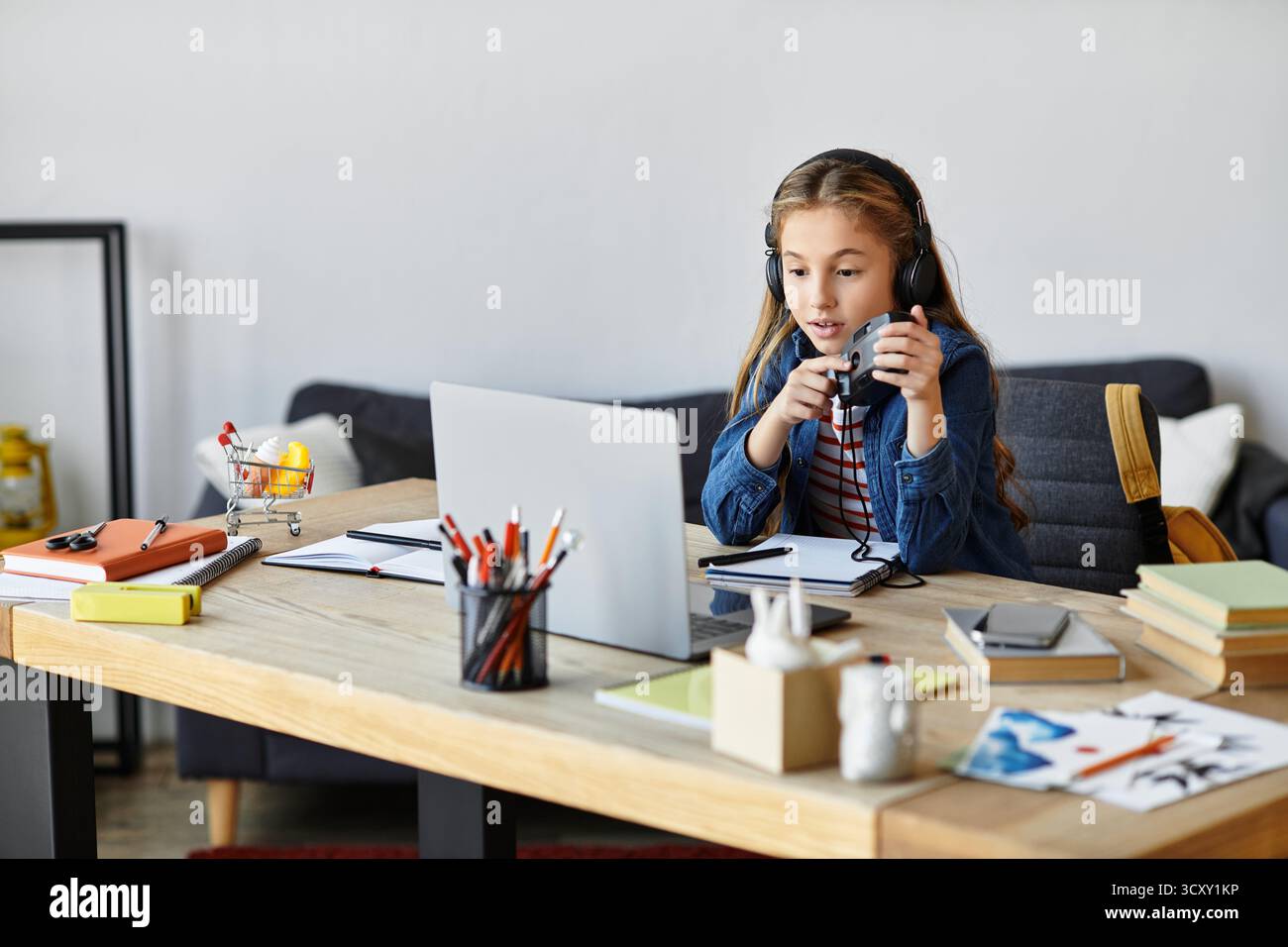 Una ragazza con un outfit casual che tiene una fotocamera retrò vicino a un notebook, un divertimento alfa di generazione Foto Stock