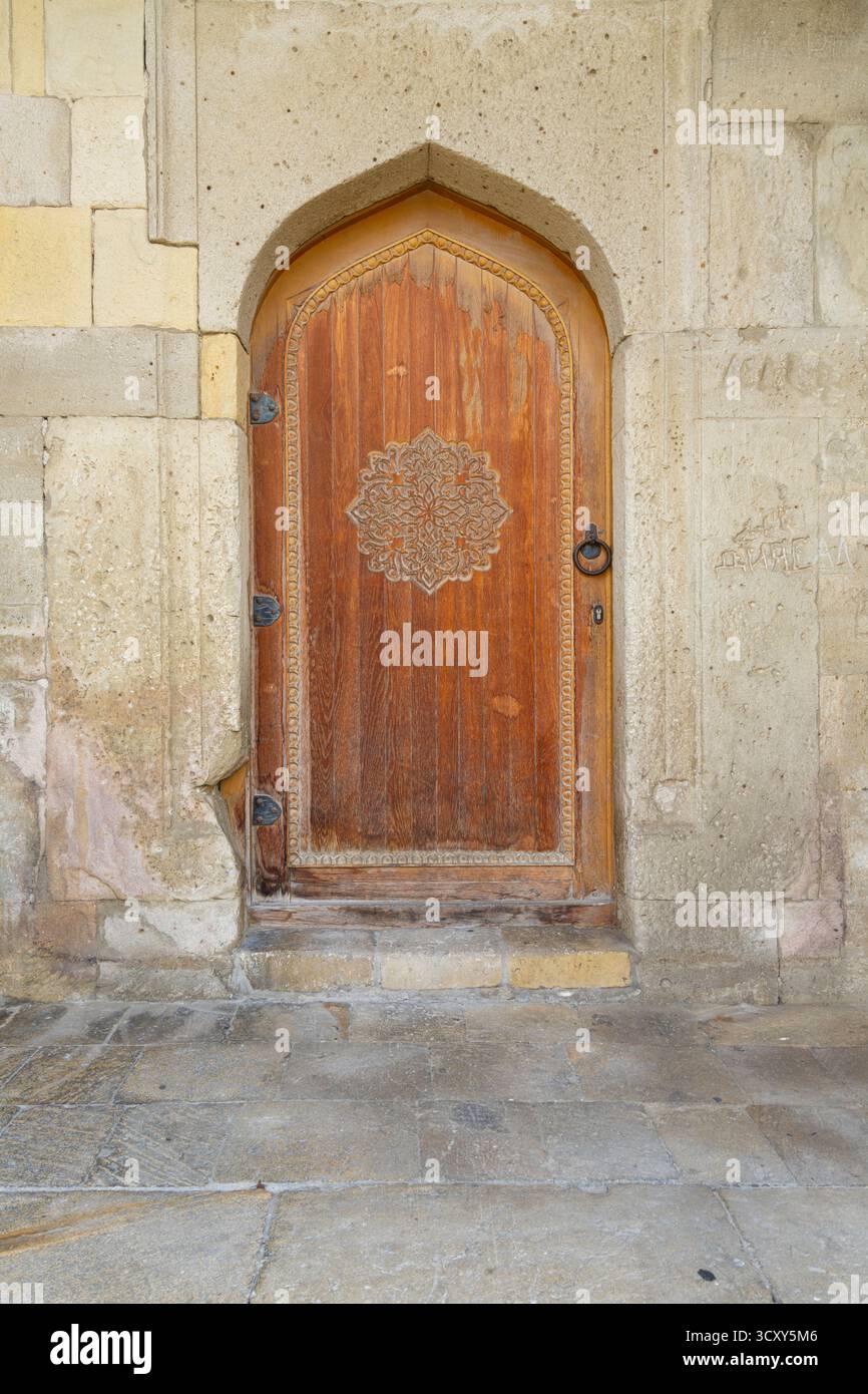 Baku, Azerbaigian. 9 ottobre 2025. antica porta in legno decorata di una casa nel centro storico della città Foto Stock