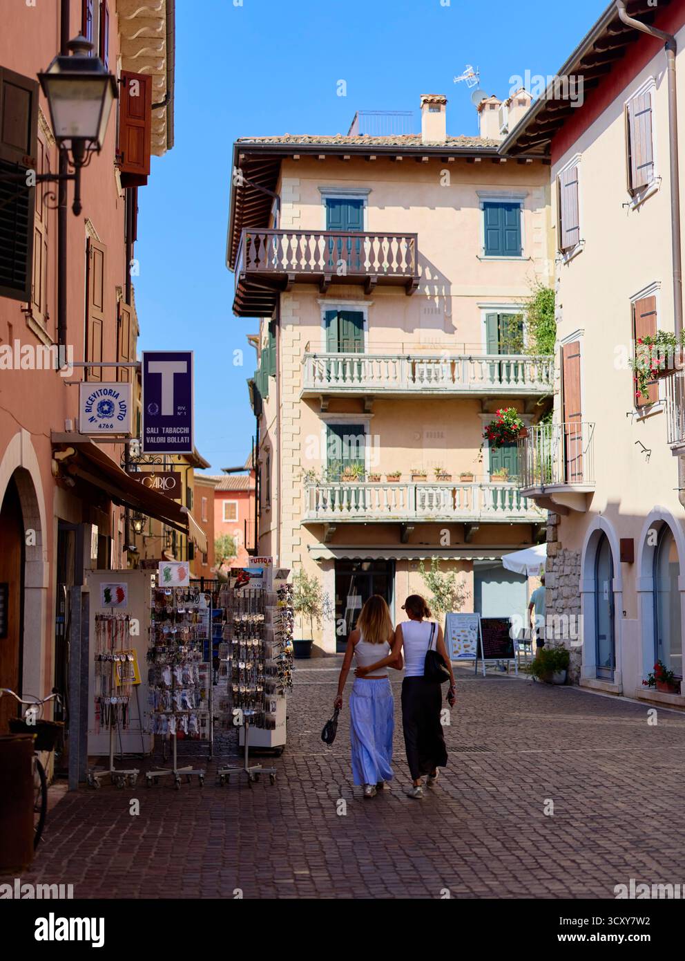 Scena di strada con due turisti femminili che camminano per Torri, Italia Foto Stock