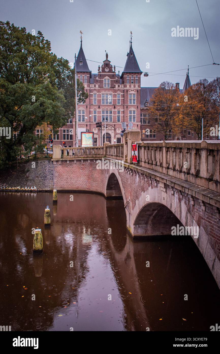 Un bel canale con un affascinante ponte che conduce ad un edificio storico con sorprendenti dettagli architettonici. Foto Stock