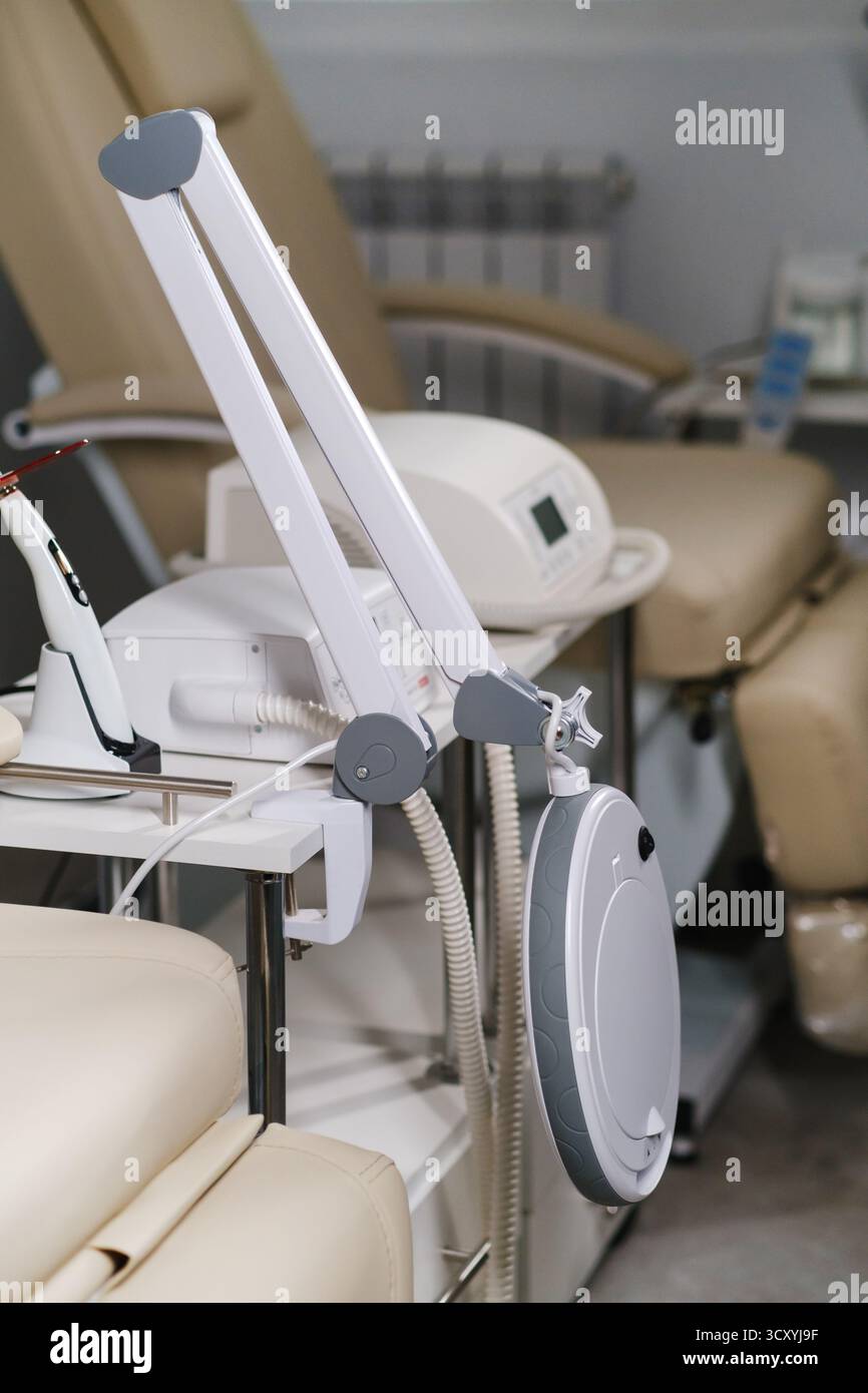 Un tranquillo centro benessere dispone di una poltrona massaggiante e di strumenti avanzati pronti per il relax dei clienti. L'illuminazione soffusa migliora l'atmosfera rilassante, inviti Foto Stock