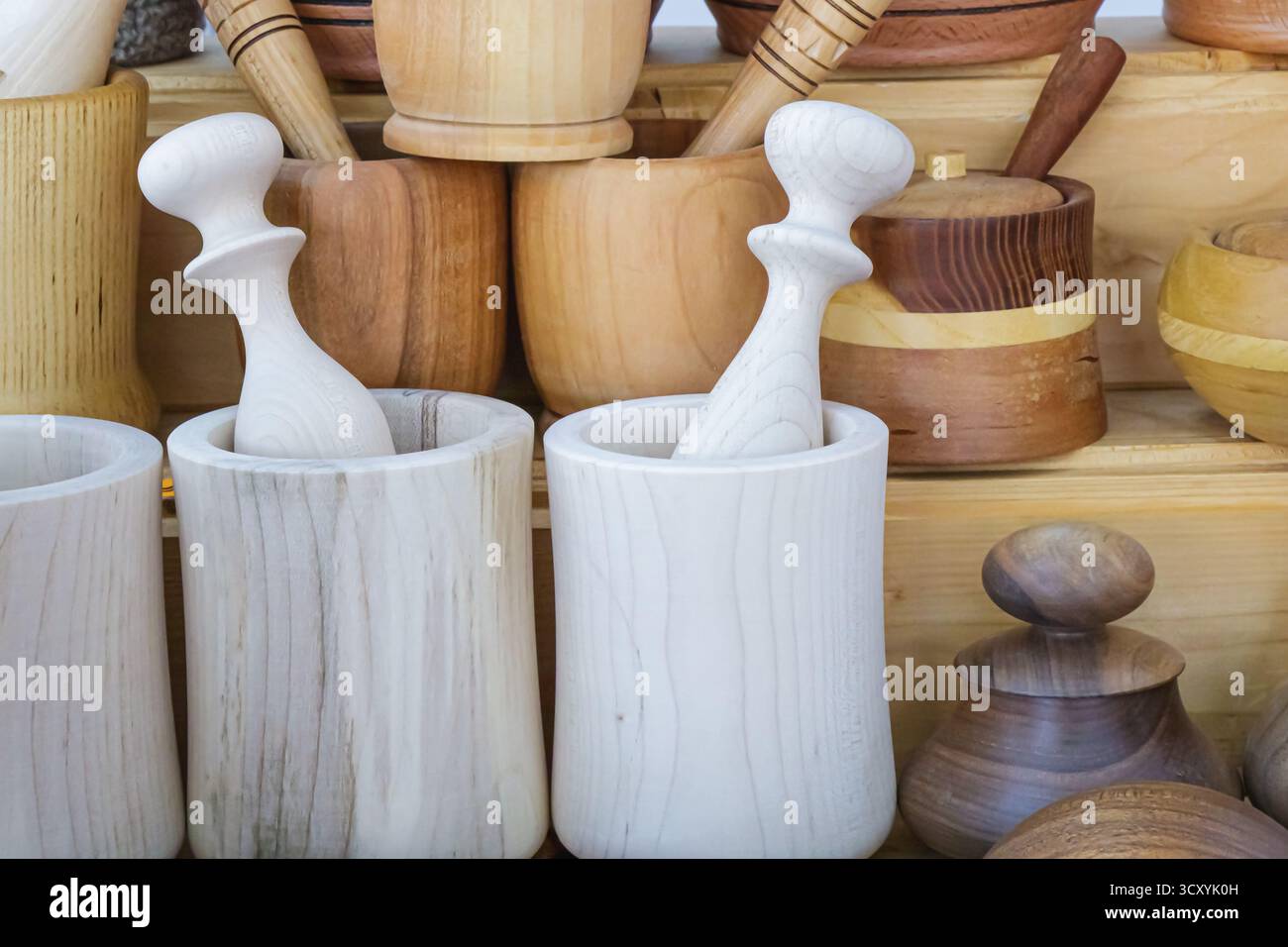 Collezione di mortai e pestelli in legno fatti a mano disposti in mostra, mettendo in risalto i toni del legno naturale, l'artigianato e il fascino rustico Foto Stock
