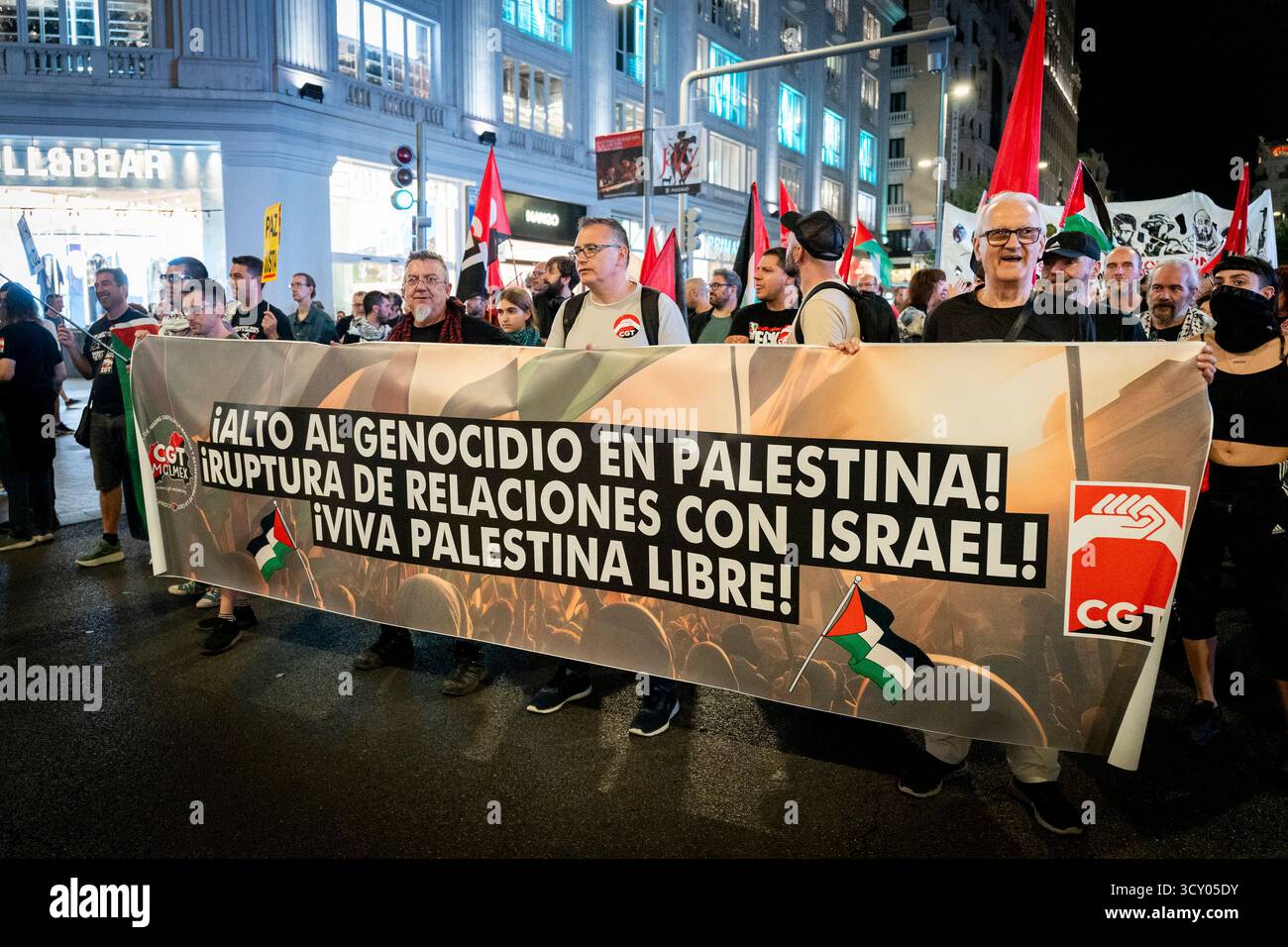 Diversi manifestanti hanno un'enorme bandiera con lo slogan "fermare il genocidio in palestina, interrompere le relazioni con israele, lunga vita a una palestina libera” durante la manifestazione di sostegno alla marcia per la Palestina del 15 ottobre 2025 a Madrid, in Spagna. (Crediti: Miguel Escavias/Alfa Images/Alamy Live News) Foto Stock