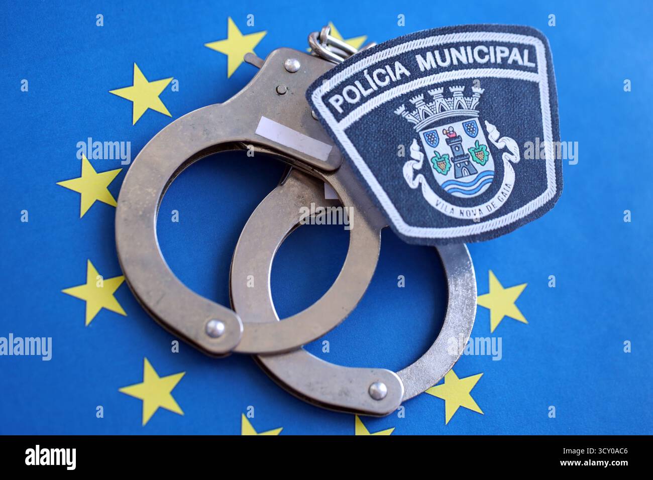 KIEV, UCRAINA - 6 SETTEMBRE 2025 Portogallo polizia municipale patch e manette sulla bandiera blu dell'Unione europea primo piano Foto Stock