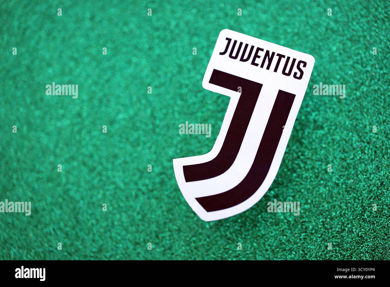KIEV, UCRAINA - 23 FEBBRAIO 2025 il distintivo della squadra di calcio della Juventus FC si trova su uno sfondo verde smeraldo glitter Foto Stock
