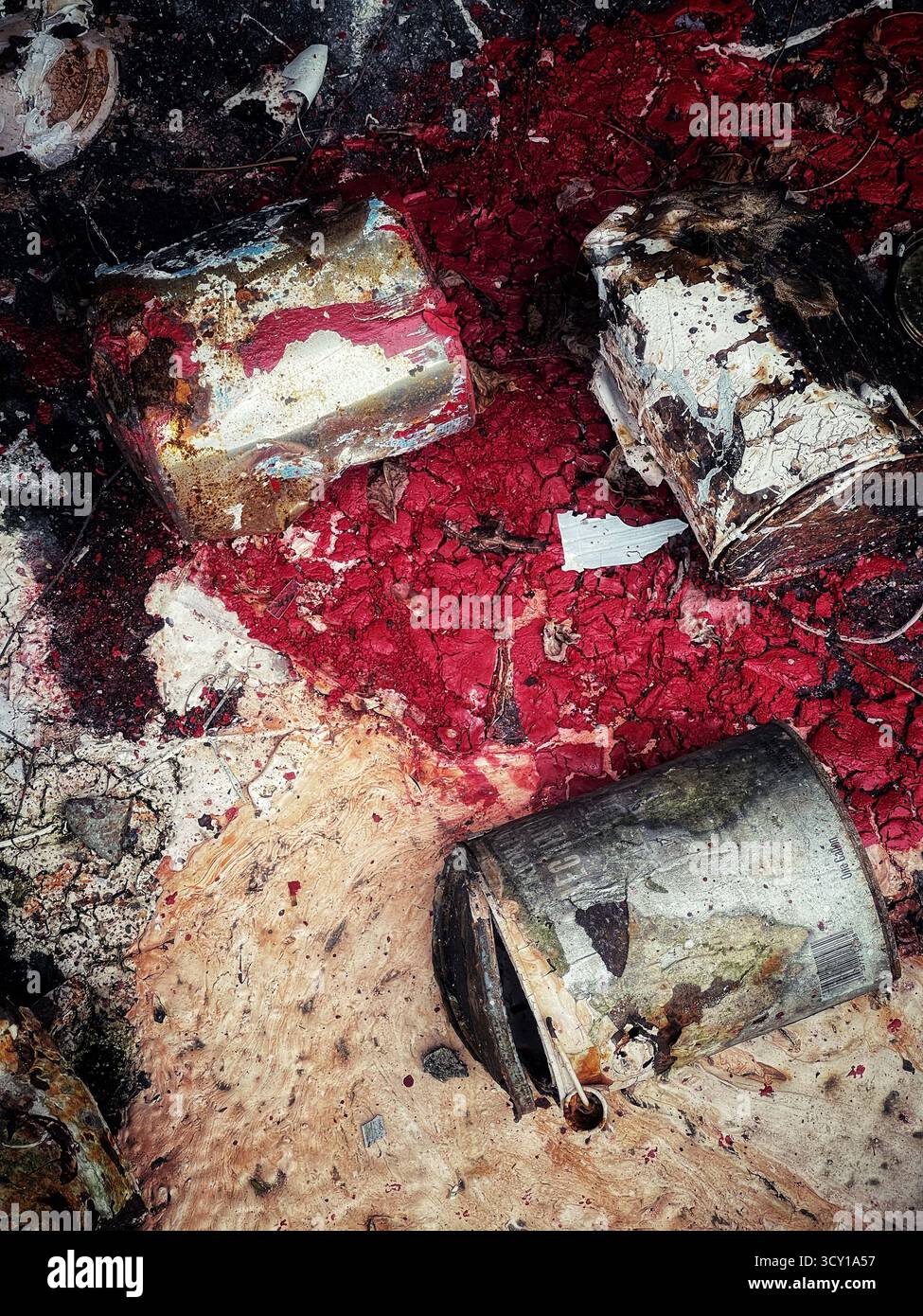 Le lattine di metallo scartate e arrugginite si trovano su uno sfondo colorato e testurizzato che mostra segni di deterioramento e decadimento in un ambiente industriale - Immagine stock catturata con smartphone