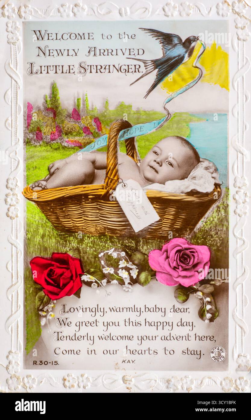 Cartolina vintage che celebra la nascita con il bambino in un cestino, fiori, uccello e versi. Foto Stock