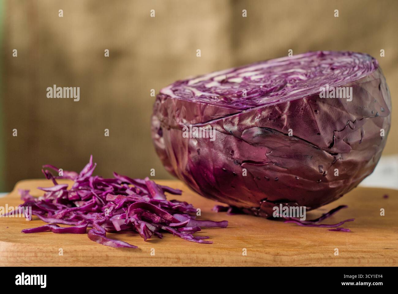 Un primo piano di un mucchio di cavolo rosso viola appena tritato su un tagliere di legno Foto Stock
