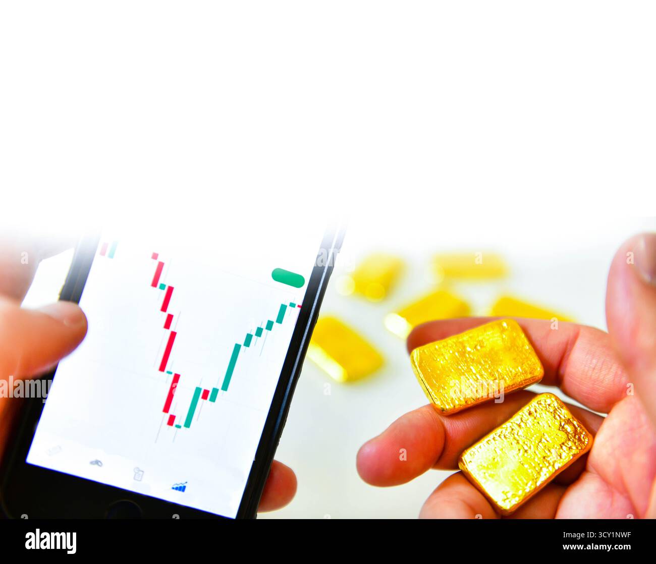 Mano che tiene in mano uno smartphone e una barra d'oro per controllare il grafico del prezzo dell'oro per l'investimento e lo spazio di copia Foto Stock