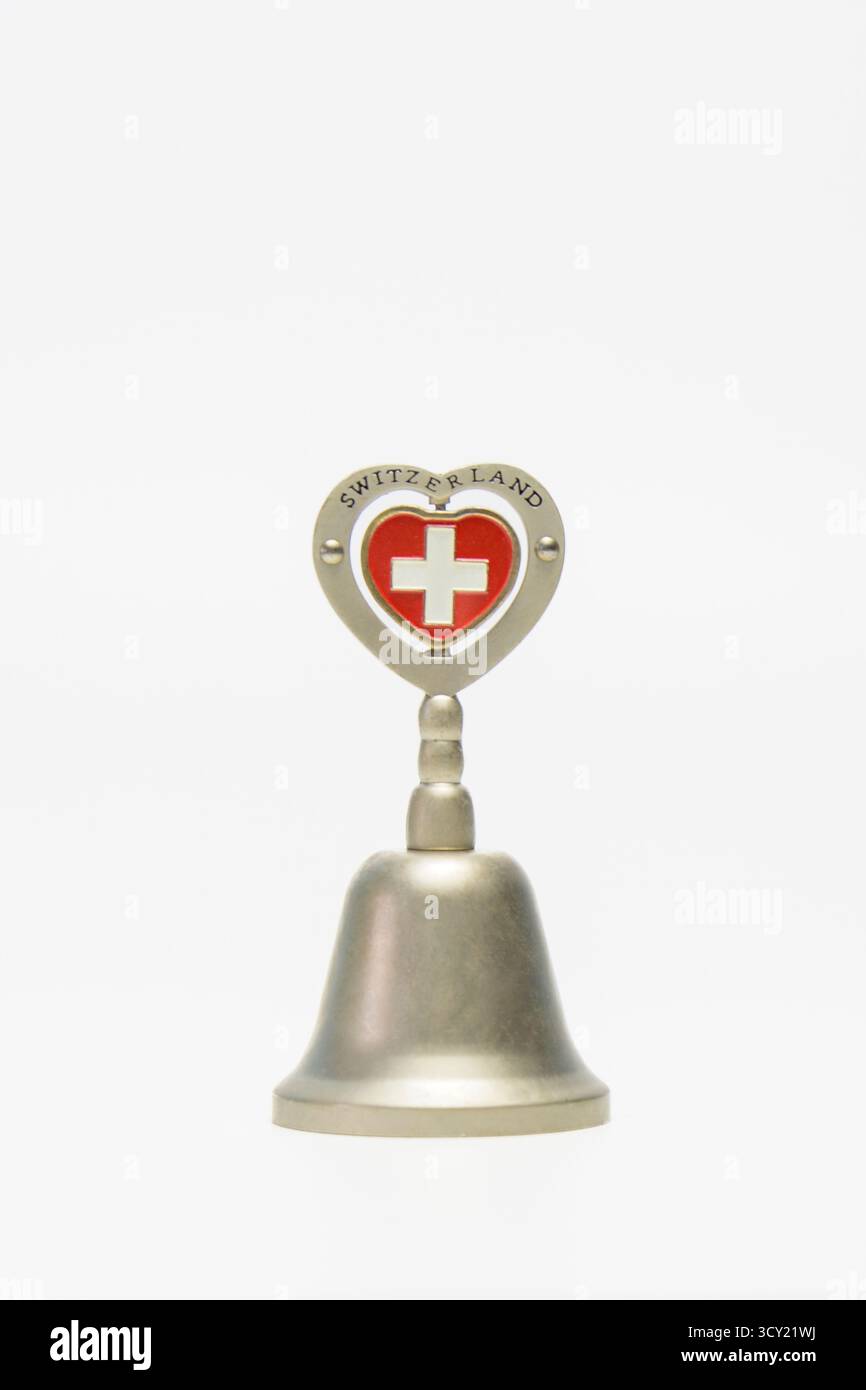 Hasselt. Limburgo - Belgio 13-03-2024. Piccola campana in metallo ricordo con motivi e incisioni. Iscrizione Svizzera. Su sfondo bianco Foto Stock