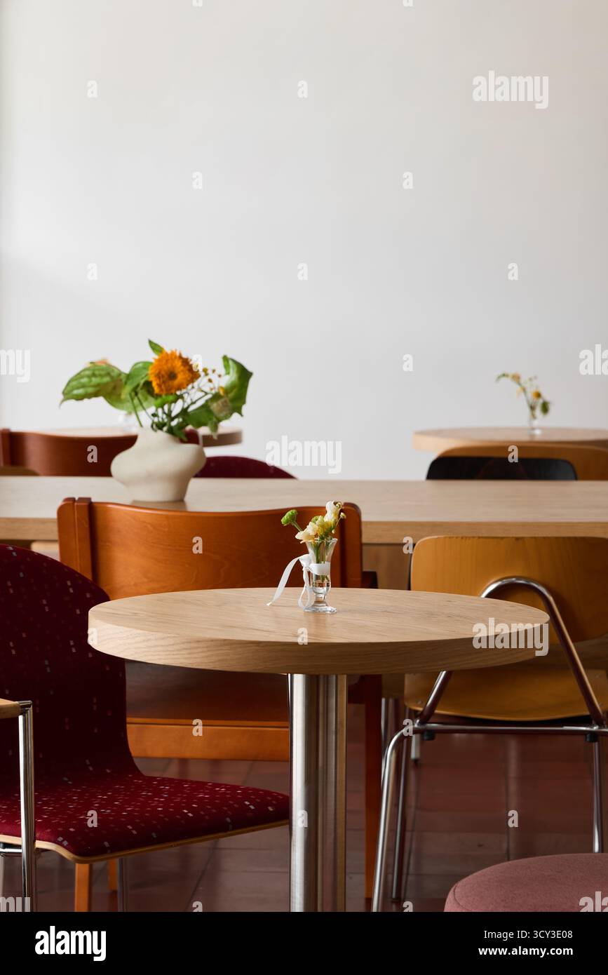 Intimo caffè interno con tavoli in legno e sedie colorate Foto Stock