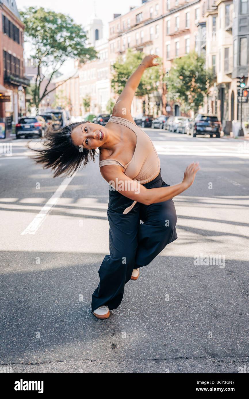 Donna che danzava energicamente sulla strada urbana della città Foto Stock