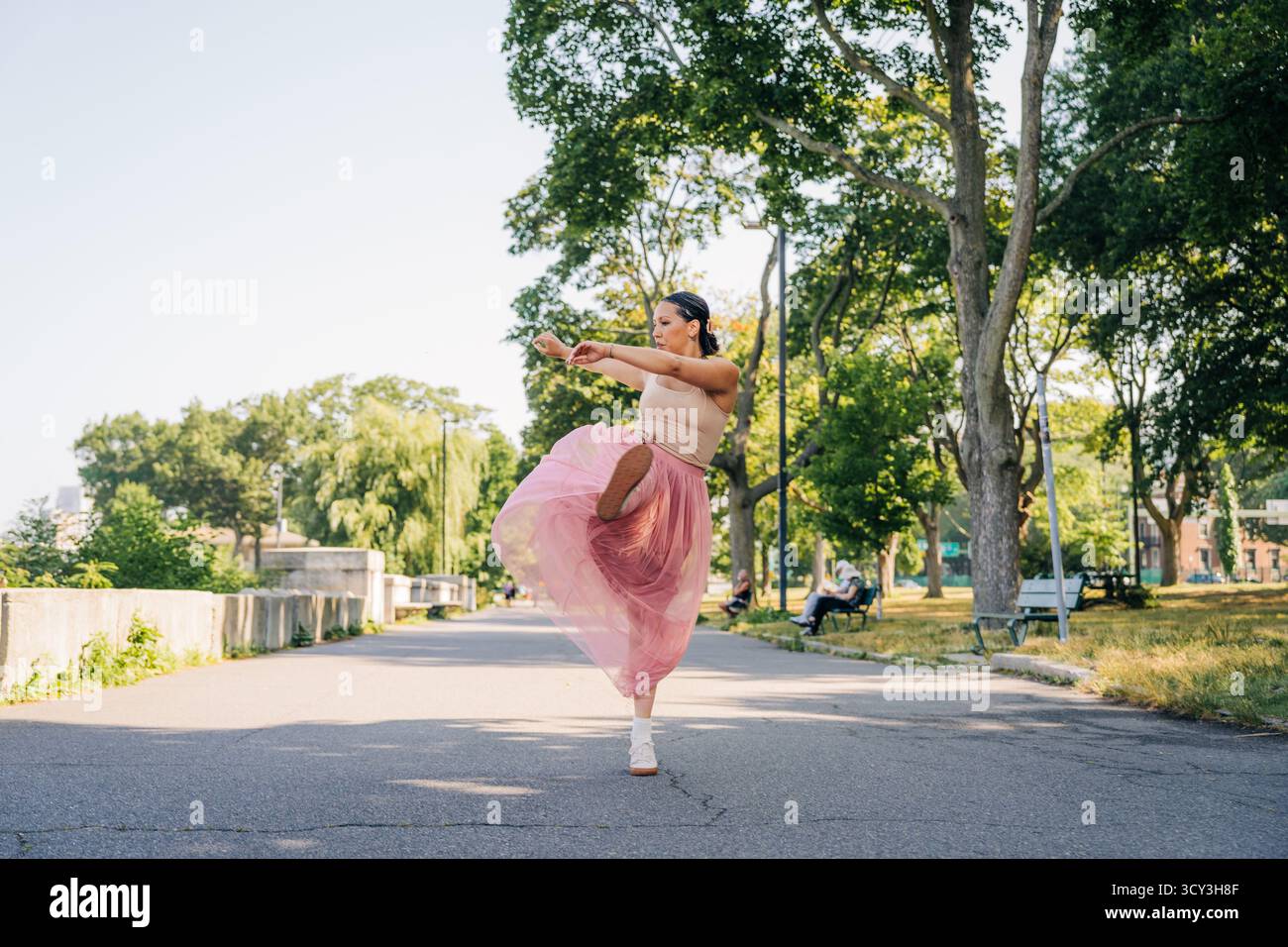 Donna che balla graziosamente nel parco godendo di libertà e movimento Foto Stock