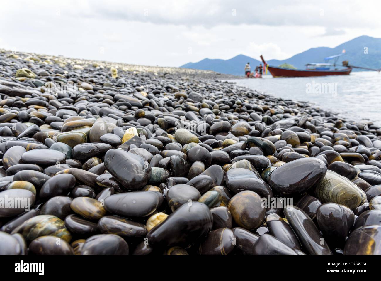 Barca dalla coda lunga portano i turisti viaggiare a Ko Hin Ngam isola e bella roccia con uno strano colore nero è un famoso attrazioni di Tarutao National Foto Stock
