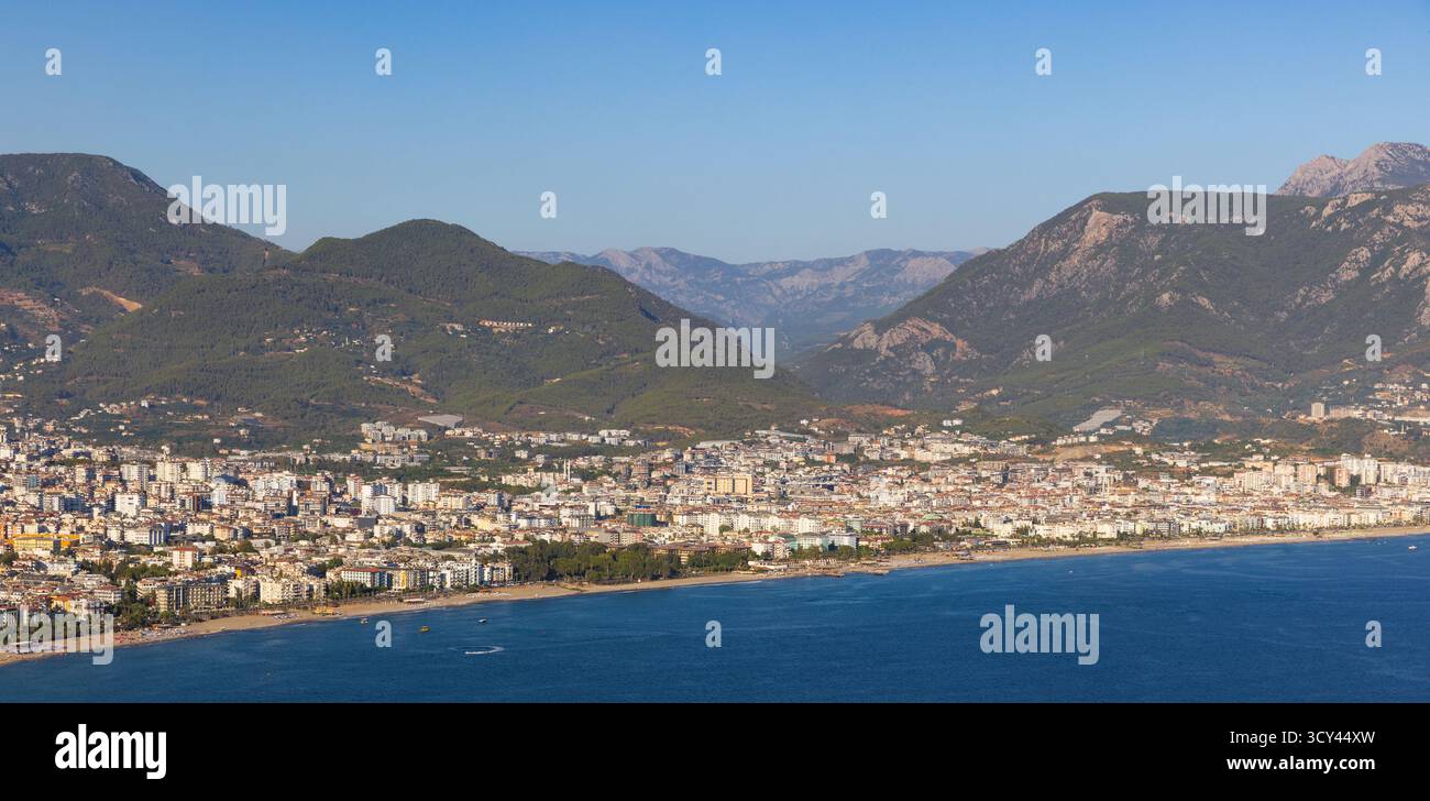 Un'ampia vista di una città di mare costruita lungo la riva, adagiata su verdi montagne. Alanya in una giornata di sole, acque calme, vivace vita urbana, perfetto per Foto Stock Un'ampia vista di una città di mare costruita lungo la riva, adagiata su verdi montagne. Alanya in una giornata di sole, acque calme, vivace vita urbana, perfetto per Foto Stock