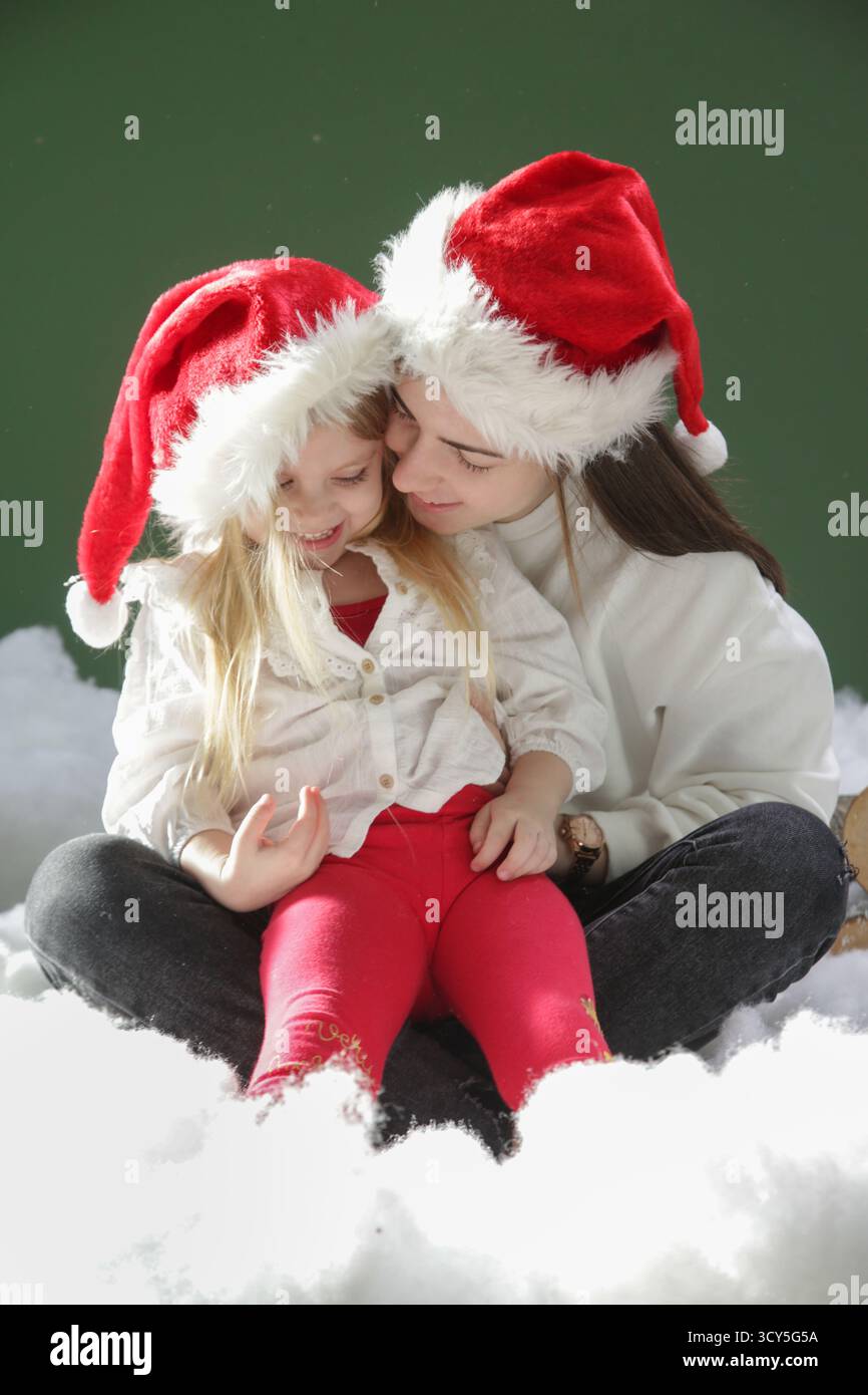 Joyful Winter Moment - due sorelle sorridenti insieme in una scena festosa di studio Foto Stock