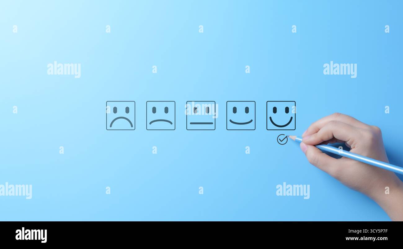 Valutazione della soddisfazione del cliente in base alle facce Smiley. Una mano segna un volto felice in un sondaggio sulla soddisfazione del cliente con varie opzioni emoticon Foto Stock