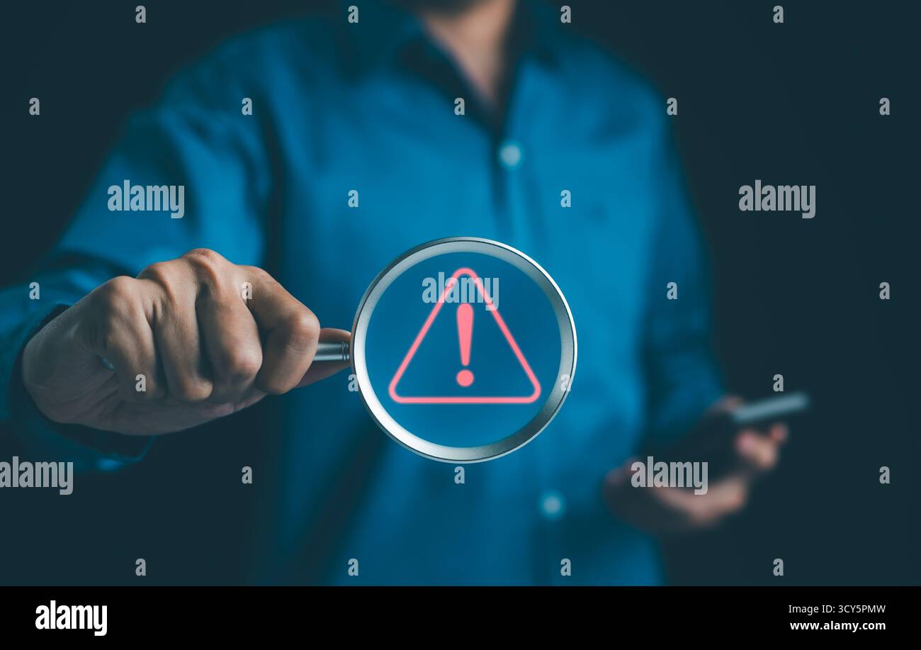Informazioni sul sistema di allarme. Uomo con lente d'ingrandimento messo a fuoco su un punto esclamativo luminoso, segnale di avvertimento rosso. hack sulla rete informatica, crimine Foto Stock