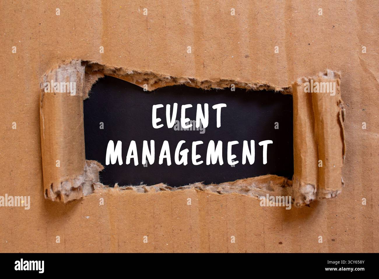 Messaggio di gestione eventi scritto su carta strappata di cartone su sfondo nero. Simbolo della gestione concettuale degli eventi. Copia spazio. Foto Stock