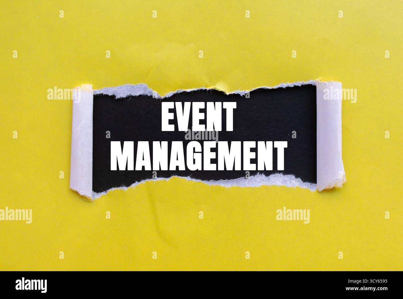 Messaggio di gestione eventi scritto su carta gialla strappata su sfondo nero. Simbolo della gestione concettuale degli eventi. Copia spazio. Foto Stock