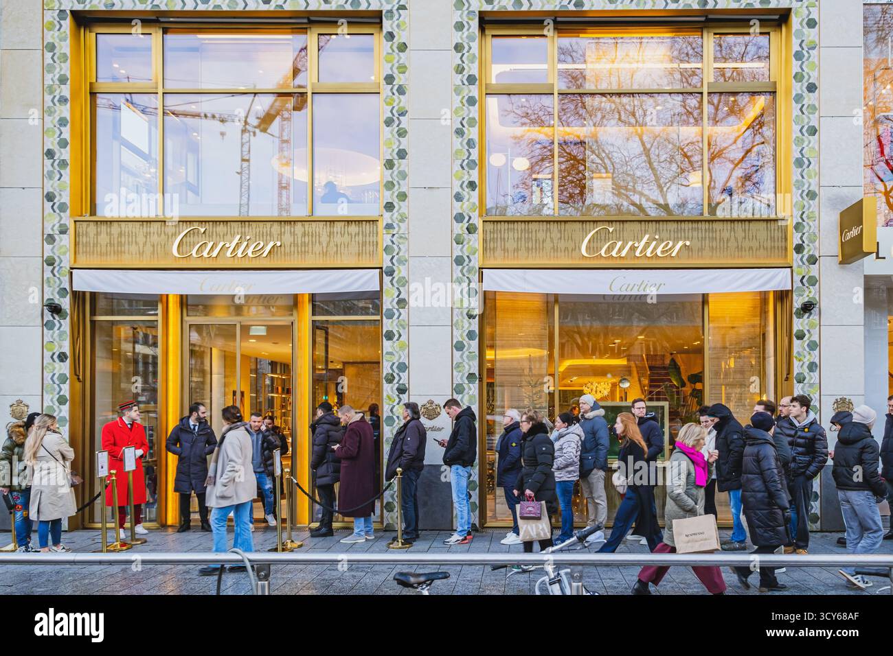 I clienti aspettano in fila per entrare nel negozio di gioielli di lusso Cartier Foto Stock