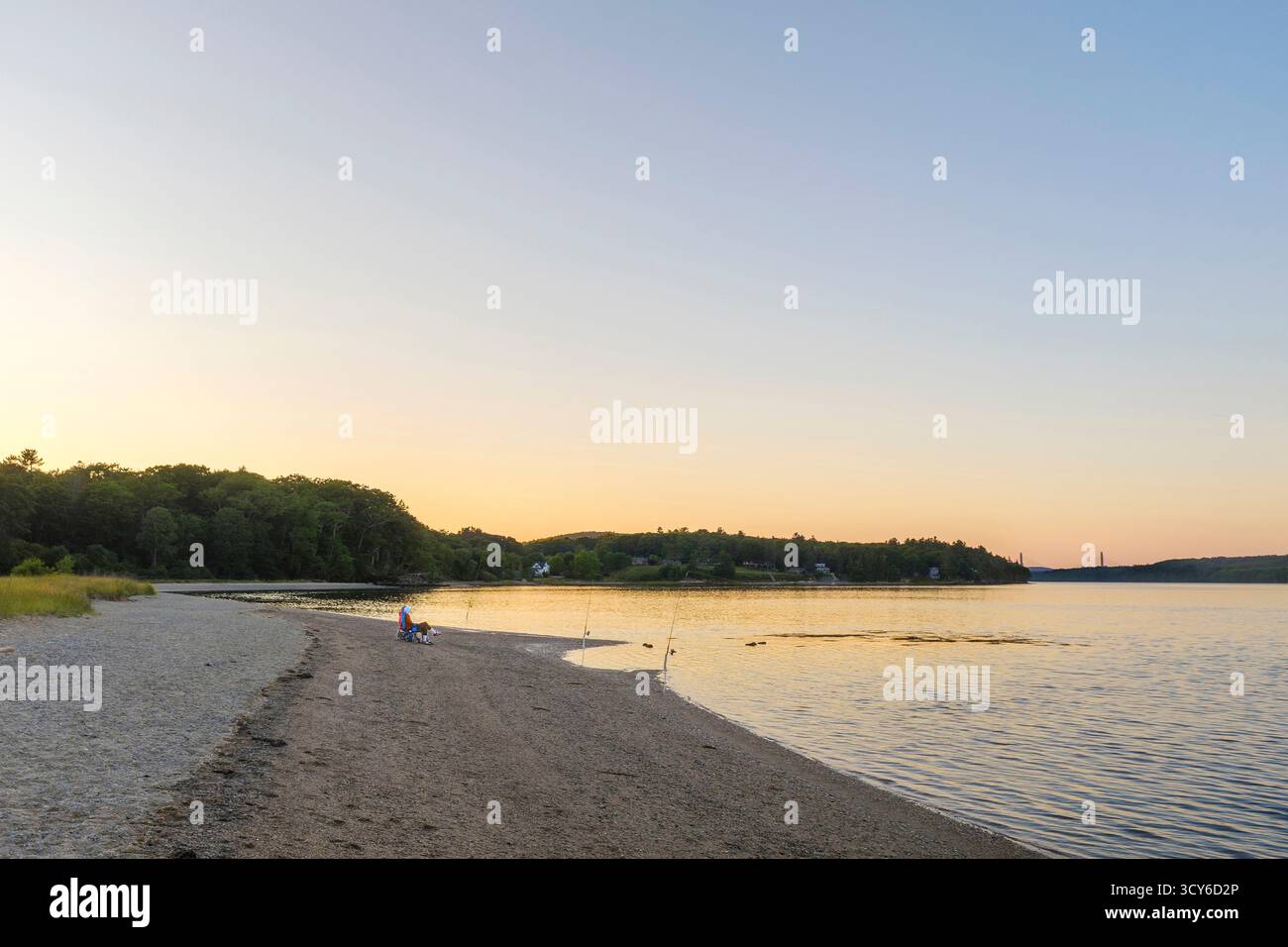 Due persone che pesca in spiaggia al tramonto Foto Stock