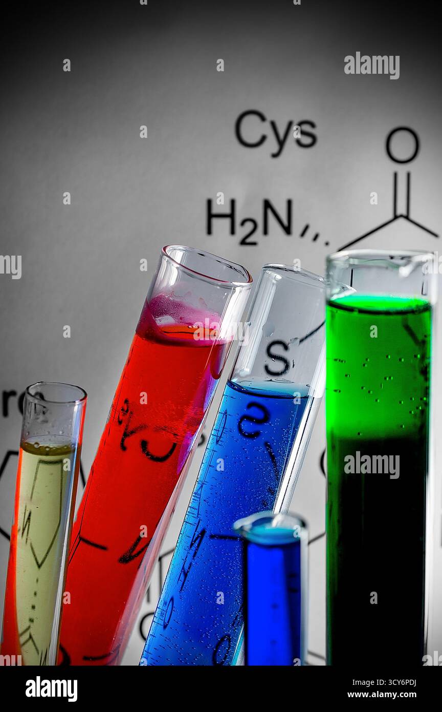 Provette colorate con liquidi gialli, rossi, verdi e blu disposte in laboratorio Foto Stock