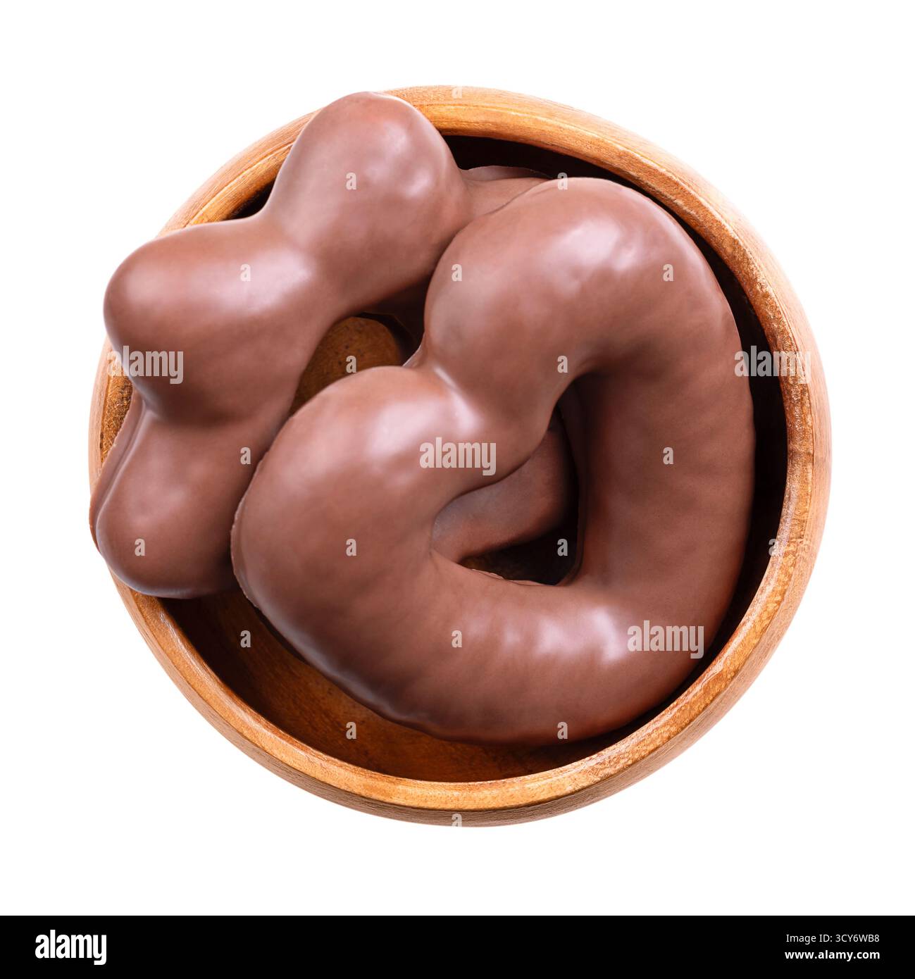 Pan di zenzero, immerso nel cioccolato al latte, in un recipiente di legno. Lebkuchen tedesco a forma di cuore e stella, tradizionale pan di zenzero piccante, soffice e morbido. Foto Stock