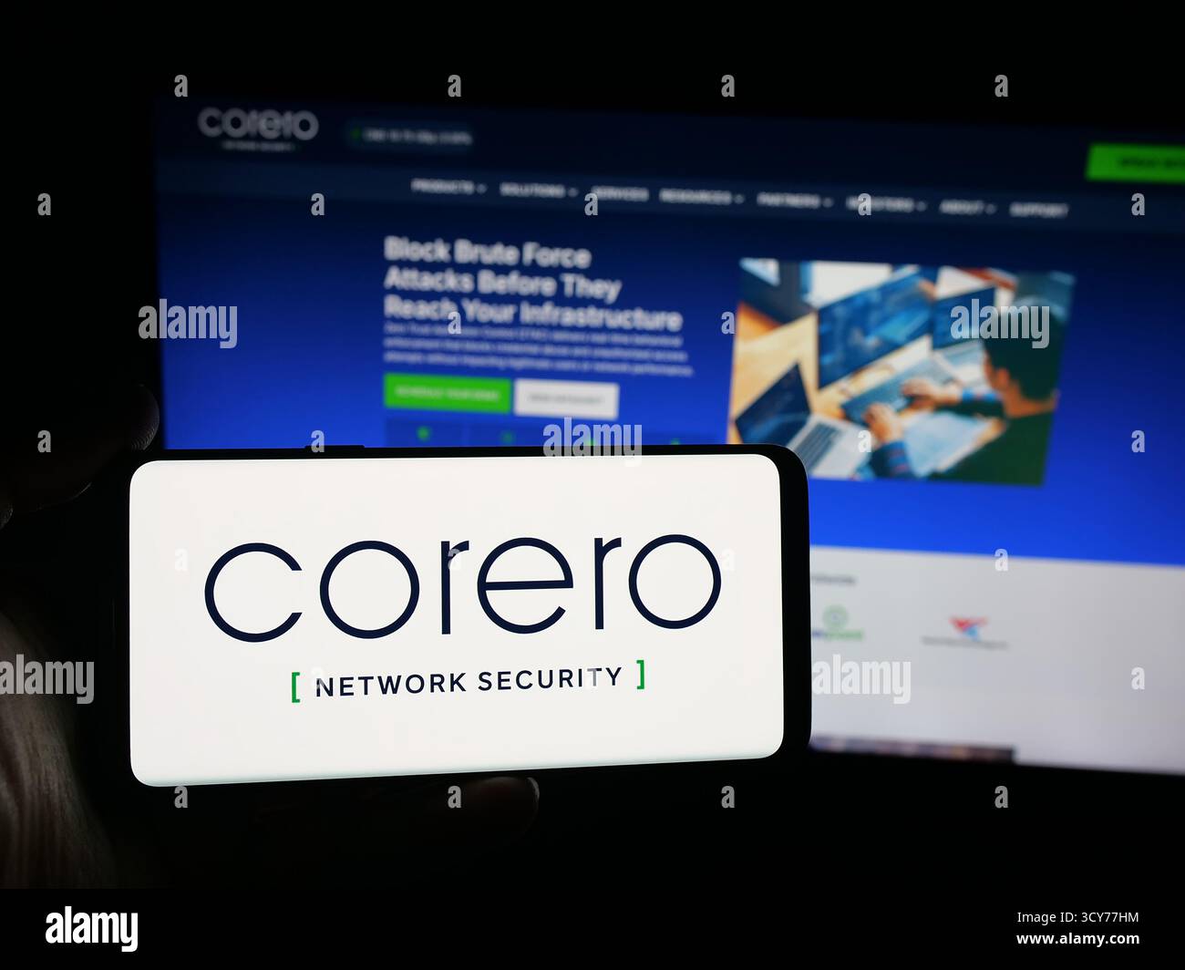 Stoccarda, Germania - 10-11-2025: Persona con smartphone con logo della società Corero Network Security sullo schermo di fronte al sito web. Foto Stock