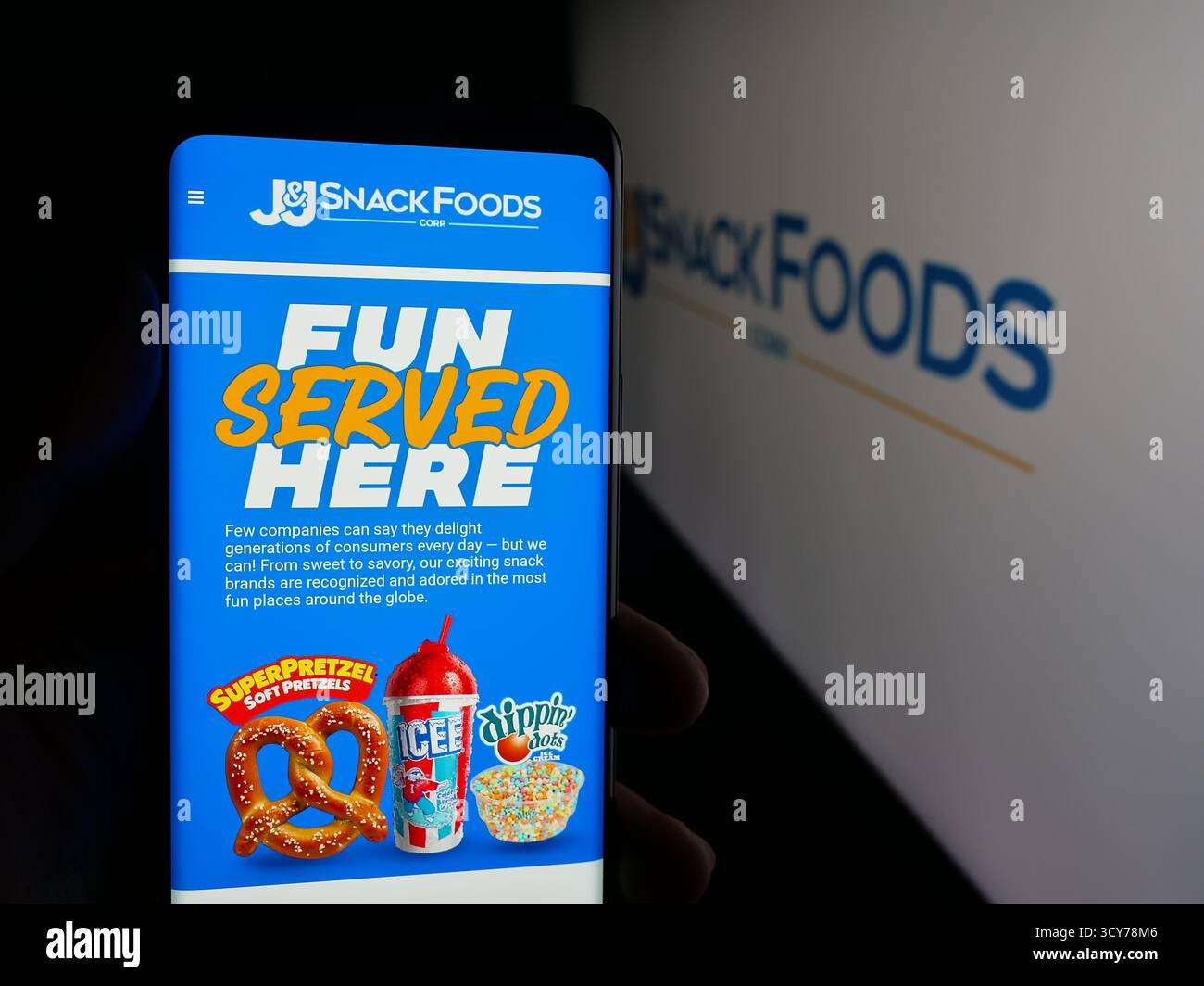Stoccarda, Germania - 10-12-2025: Persona con smartphone e pagina web dell'azienda alimentare statunitense JJ snack Foods Corp. Sullo schermo davanti al logo. Foto Stock