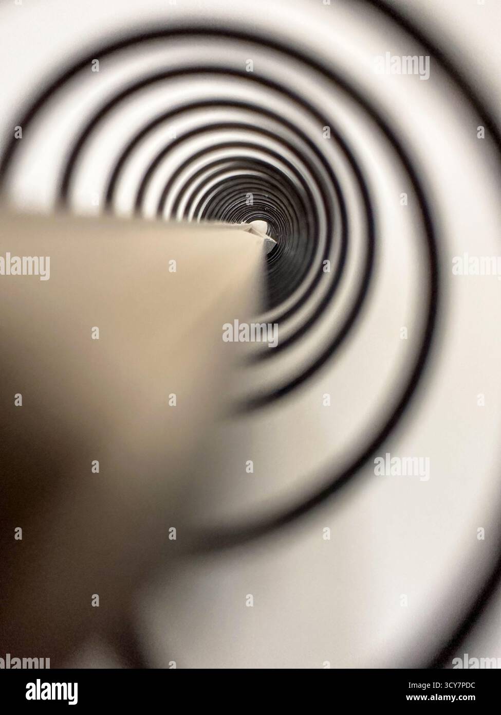 Primo piano astratto di una colonna vertebrale del libro a spirale - legame della bobina circolare con prospettiva di profondità Foto Stock