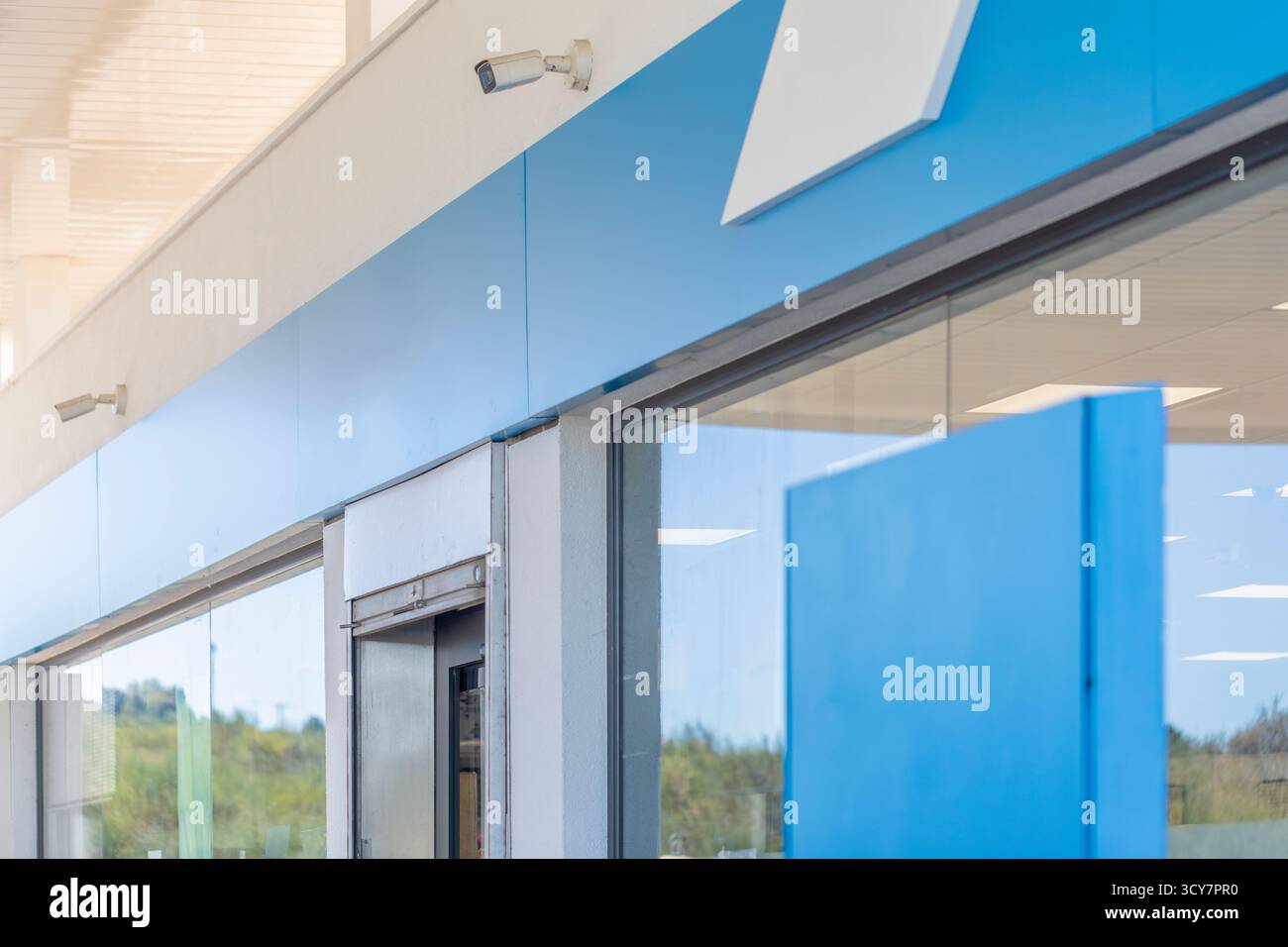Facciata principale con tendone o tettoia, dove va il logo, sopra l'ingresso di un distributore di benzina e di un negozio, perfetto per i mockup di design grafico Foto Stock
