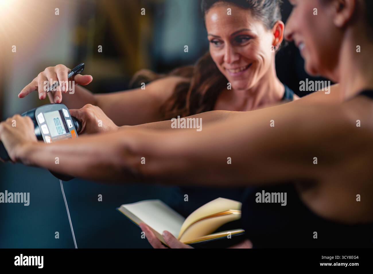 Istruttore che controlla il peso di un cliente in palestra. Foto Stock