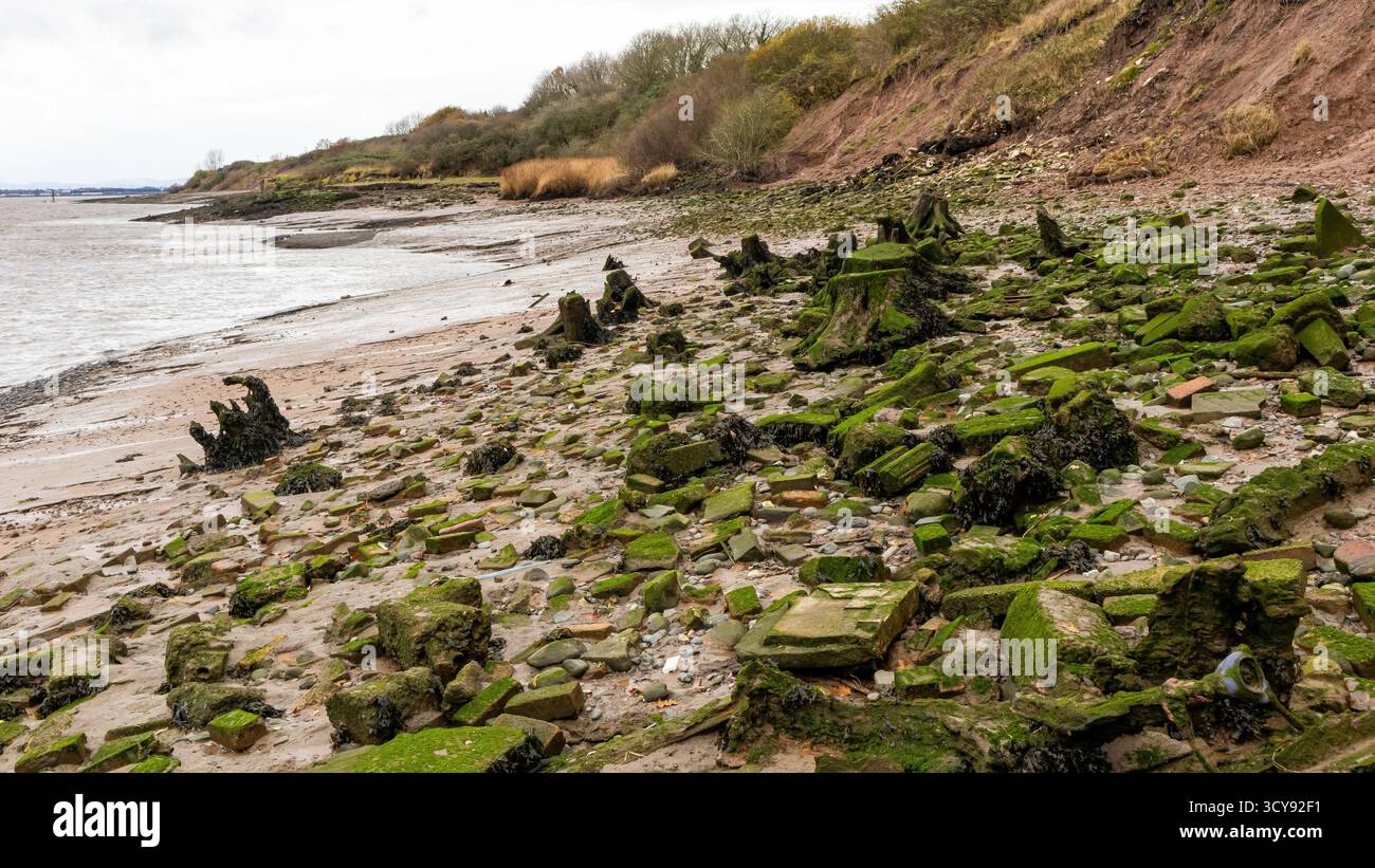 Erodendo sponde del fiume e detriti lungo la riva del fiume Mersey Foto Stock