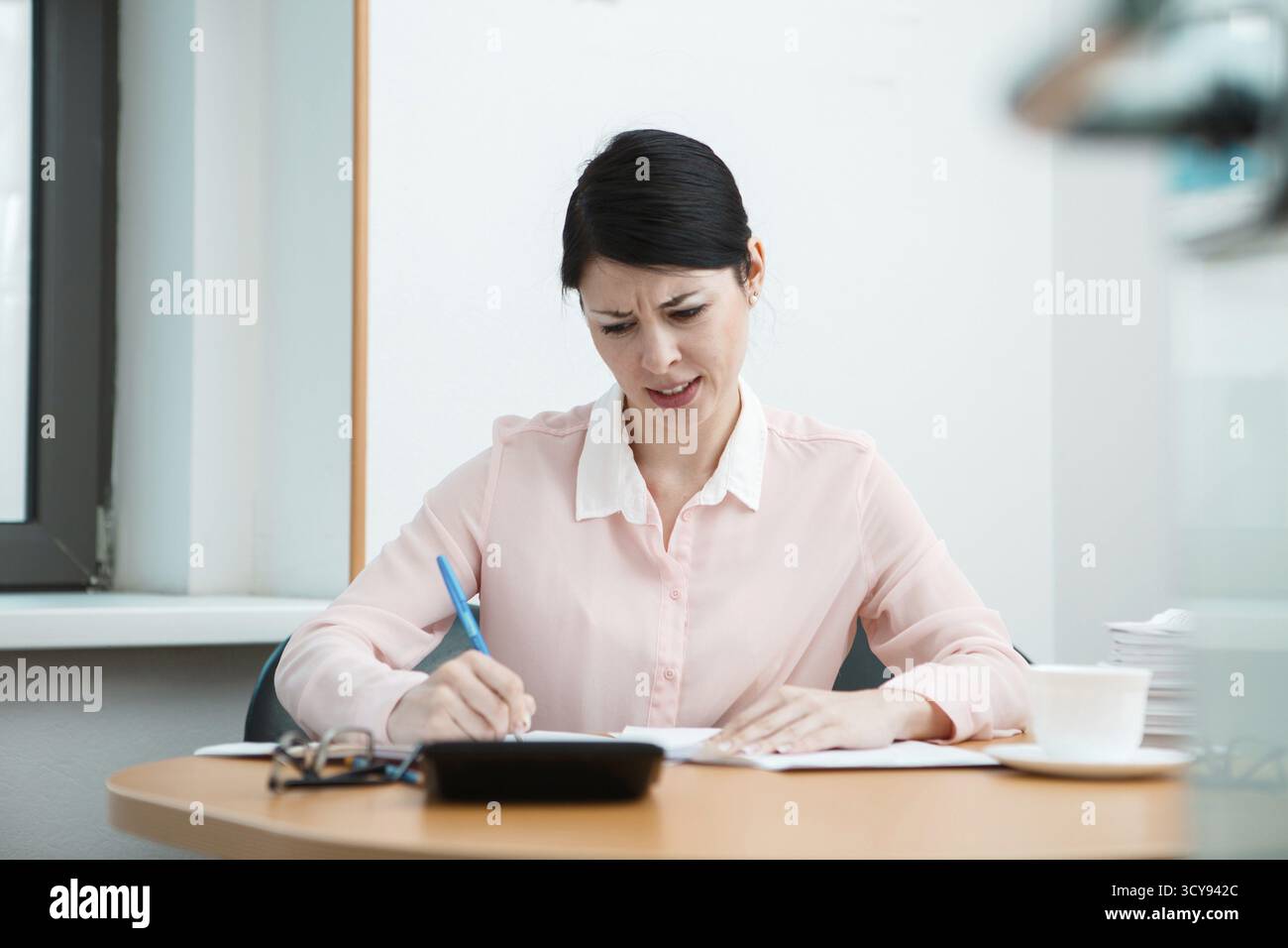 Donna in ufficio con carta sgualcita. Concetto di vita in ufficio Foto Stock