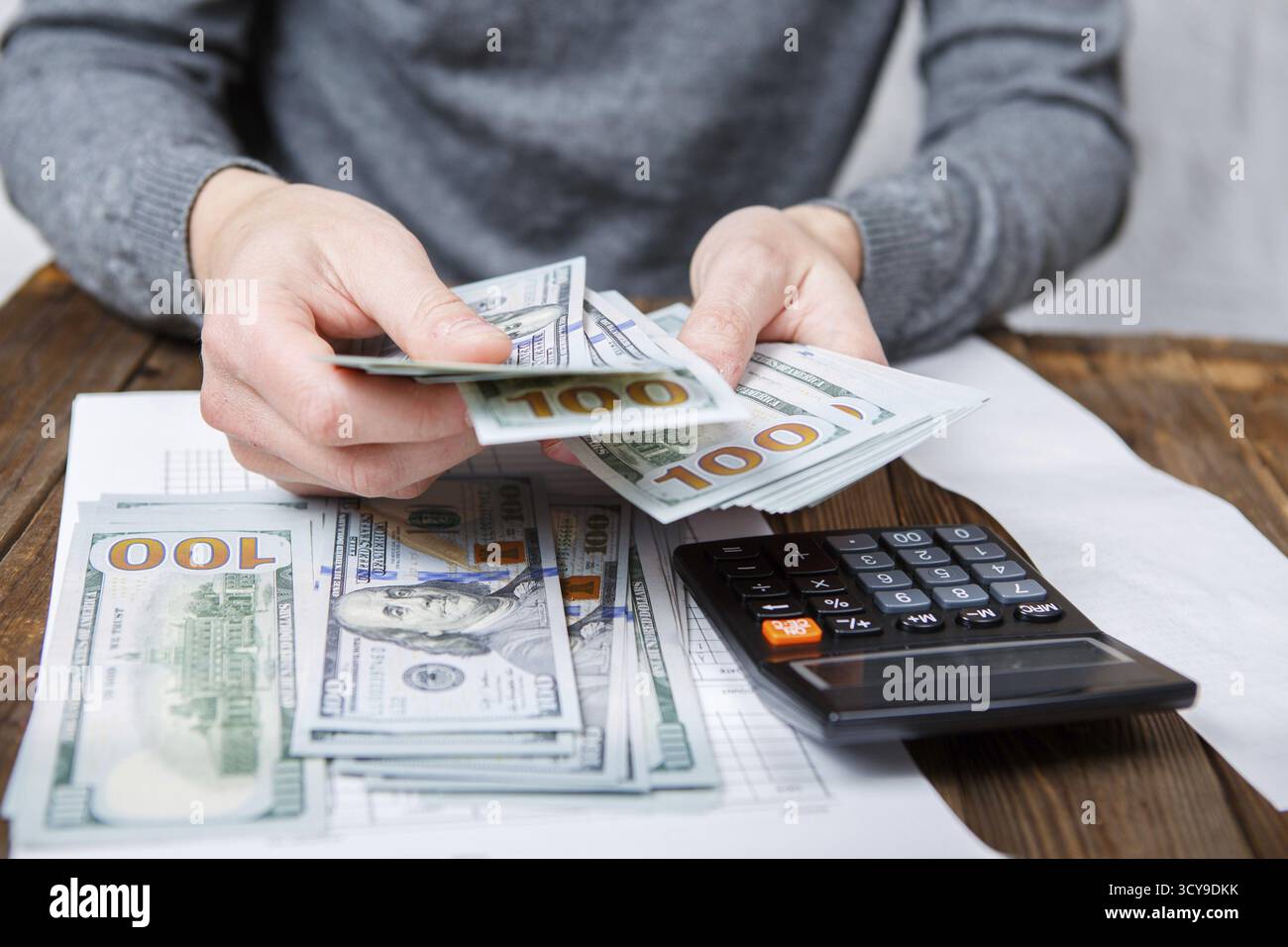 Mani caucasica conteggio banconote di dollari sul legno scuro tabella Foto Stock