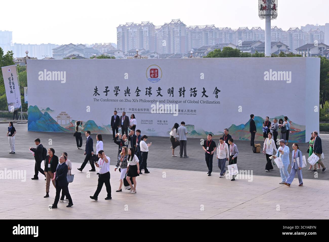 Nanping, la provincia cinese del Fujian. 18 ottobre 2025. I partecipanti passano davanti a un Consiglio per la Conferenza sulla filosofia e il dialogo della civiltà globale di Zhu Xi nella città di Nanping, nella provincia del Fujian della Cina sud-orientale, 18 ottobre 2025. La Conferenza sulla filosofia e il dialogo della civiltà globale di Zhu Xi si è tenuta qui sabato. Zhu Xi fu un grande filosofo cinese e uno studioso confuciano della dinastia Song meridionale (1127-1279). Crediti: Jiang Kehong/Xinhua/Alamy Live News Foto Stock