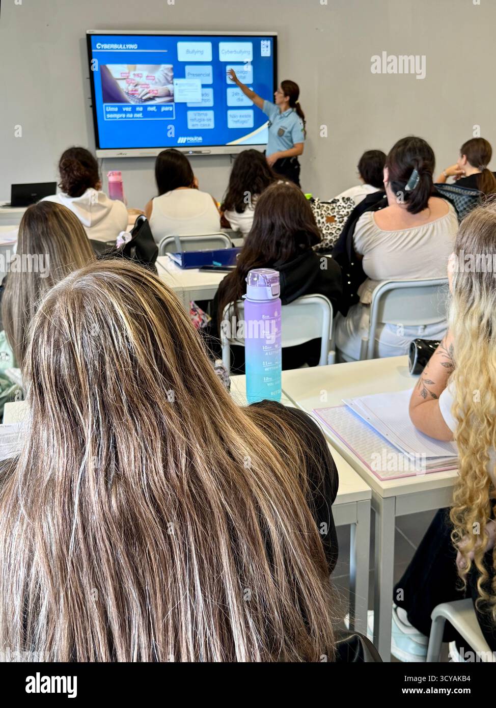 Sessione di educazione anti-bullismo condotta dalla polizia in una classe scolastica portoghese con studenti che imparano a costruire un futuro pacifico. - Immagine stock catturata con smartphone