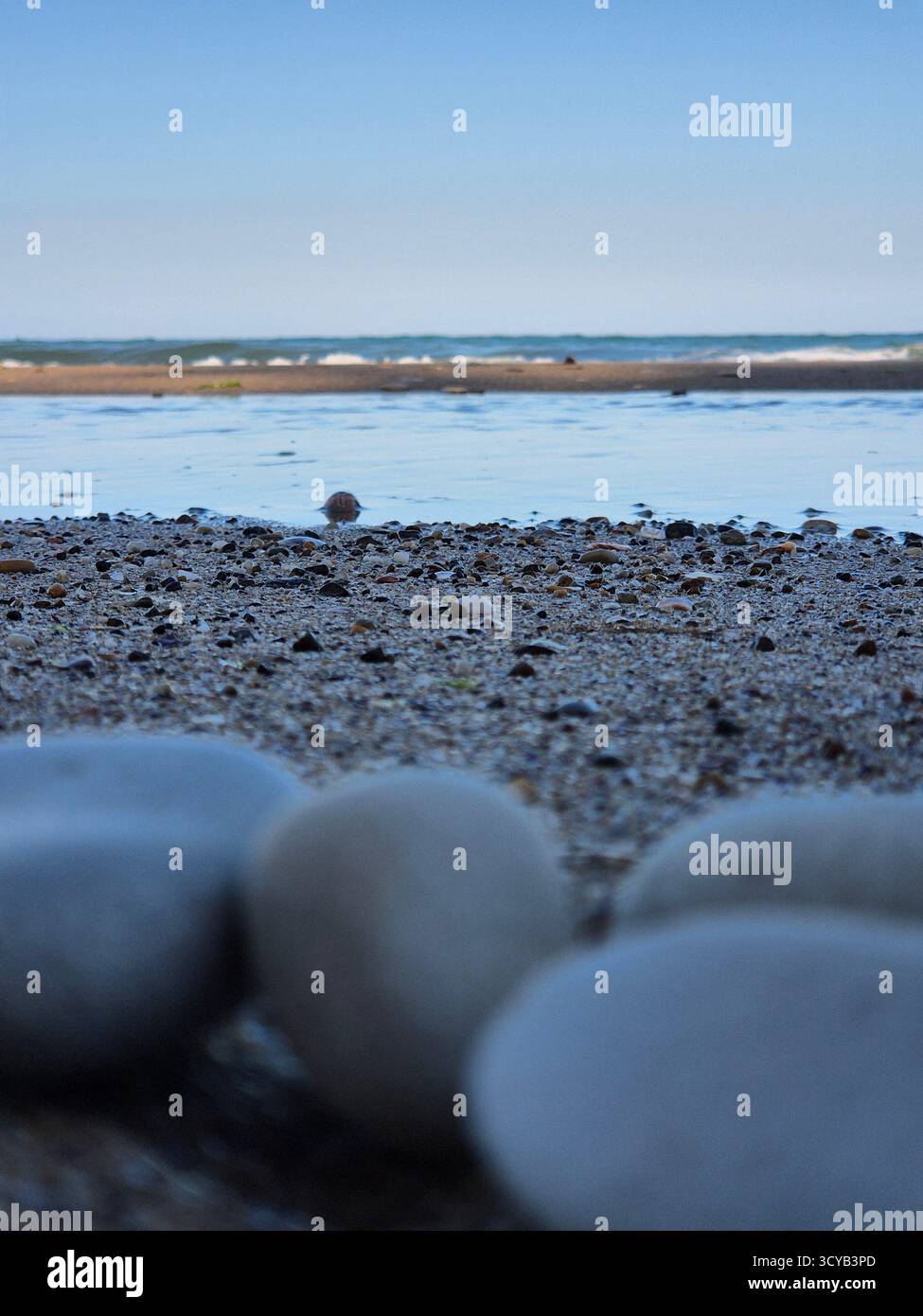 Spiaggia di ghiaia e mare calmo. primo piano con ciottoli. bellezza della natura - Immagine stock catturata con smartphone