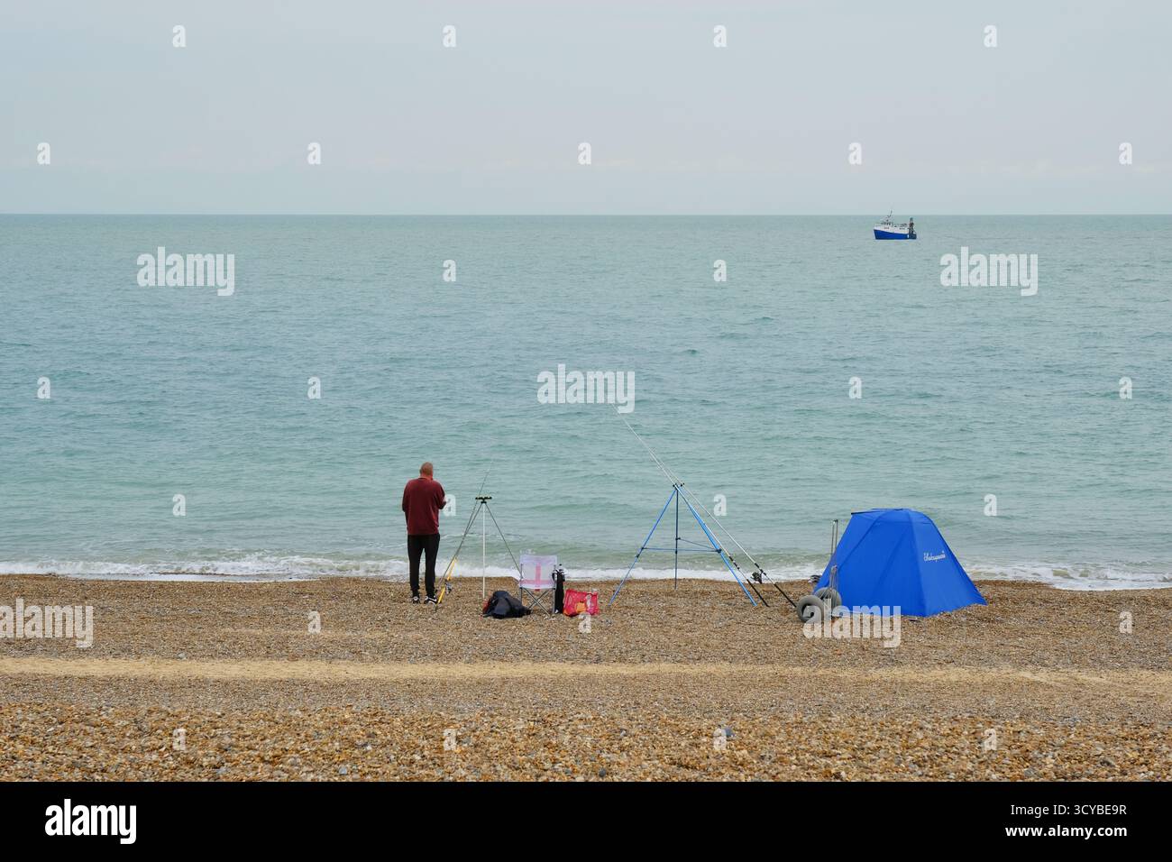 Pescatore solitario sulla spiaggia di Dunwich, Suffolk, Regno Unito Foto Stock