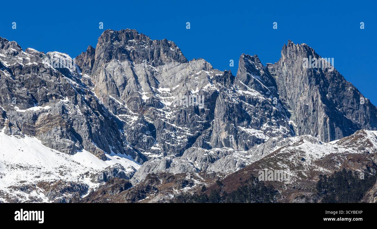 Cime rocciose innevate delle montagne innevate del Drago di Giada nella provincia dello Yunnan, Lijiang City, Cina. Paesaggio alpino e aspre formazioni geologiche. Foto Stock