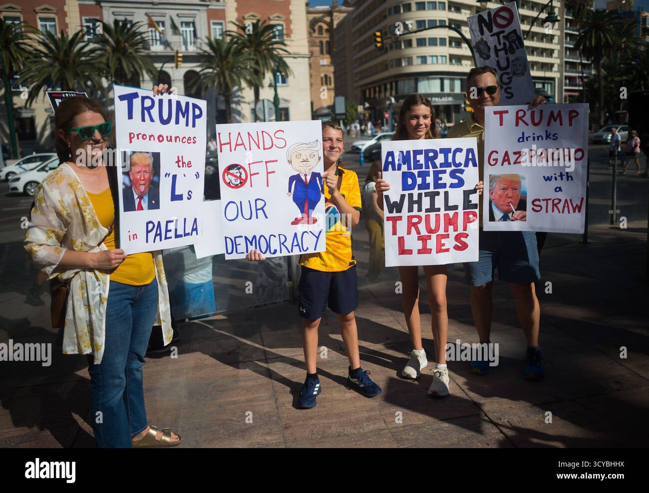 Malaga, Spagna. 18 ottobre 2025. I manifestanti sono visti tenere cartelli mentre prendono parte a una protesta contro il governo Trump, organizzata da "Democratici all'estero”, in piazza la Marina. Gli americani che vivono in Spagna hanno organizzato diverse proteste contro l’amministrazione Trump. "Democratici all'estero”, formato da cittadini statunitensi che vivono al di fuori degli Stati Uniti, è l'organizzazione ufficiale degli espatriati del Partito Democratico. Credito: SOPA Images Limited/Alamy Live News Foto Stock