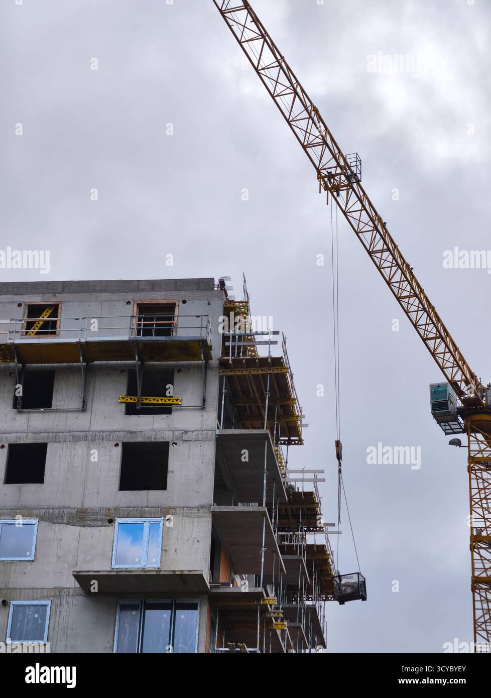 Cantiere con gru a torre e struttura in calcestruzzo parzialmente costruita ad altissima risoluzione per l'uso in ambito architettonico e industriale Foto Stock