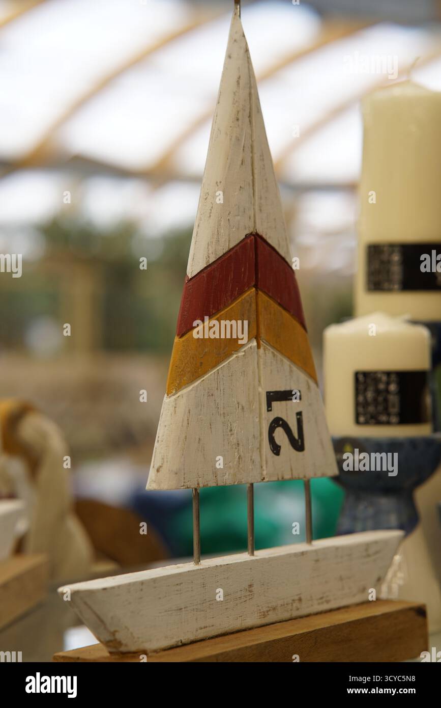 Ornamenti decorativi in legno per barche a vela in stile costiero esposti alla sezione di articoli per la casa dell'Haskins Garden Centre. Foto Stock
