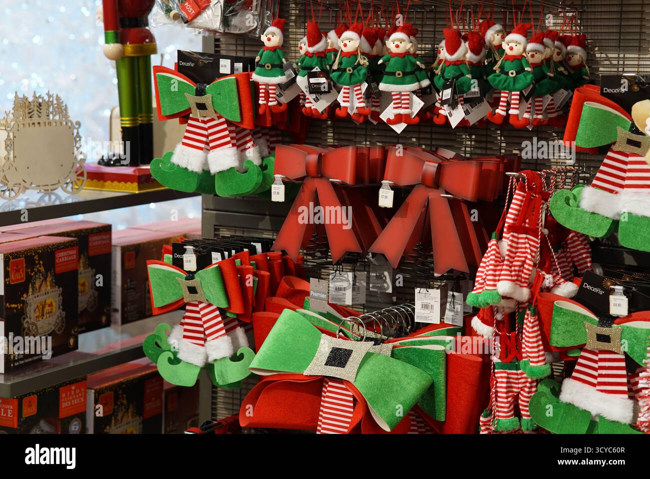 Colorate decorazioni di archi natalizi e elfi sugli scaffali delle feste presso l'Haskins Garden Centre durante la stagione dello shopping natalizio. Foto Stock