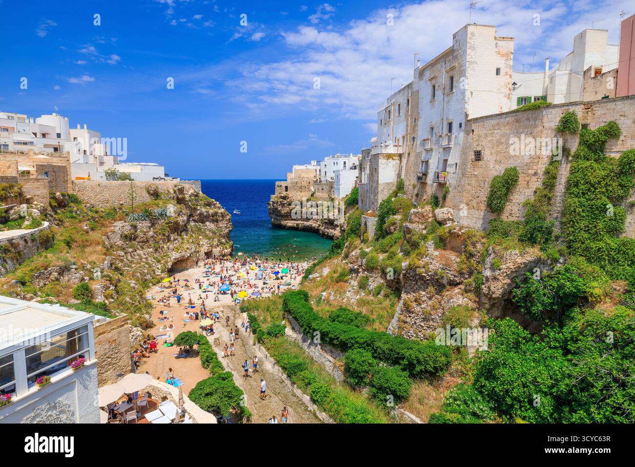 Polignano a Mare, Italia - 17 giugno 2025: Turisti che prendono il sole alla spiaggia di Lama Monachile Foto Stock