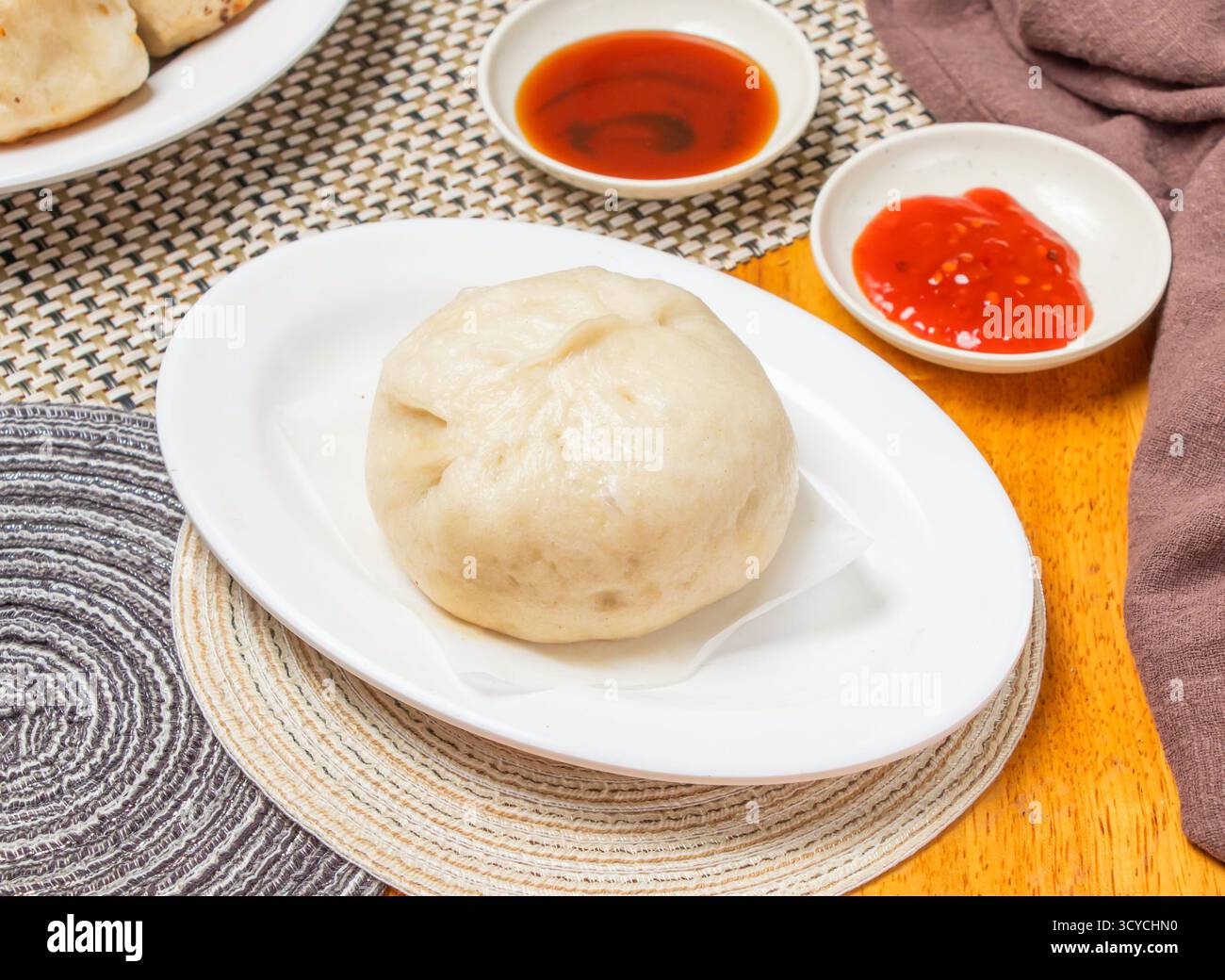 Panini di maiale al peperoncino al vapore con salsa per immersione serviti in un tovagliolo isolato con vista laterale del cibo dim sum cinese Foto Stock
